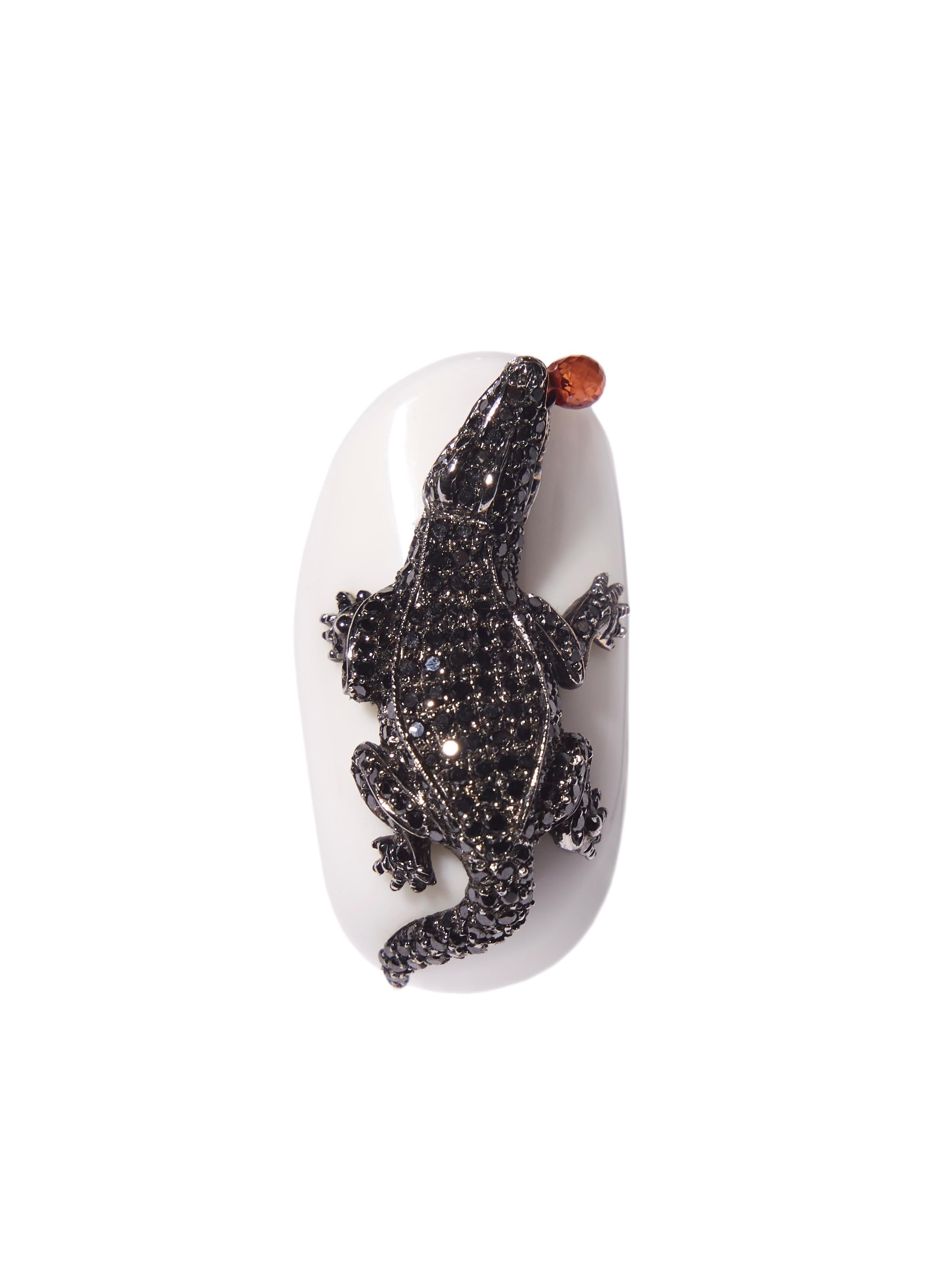 Ring sculpted in white agate decorated with an alligator paved in black diamonds. Its garnet tongue moves whilst lying in wait.. ready to attack..

Admire the beauty and craftsmanship of this piece, a ring that is truly unique; you will not find