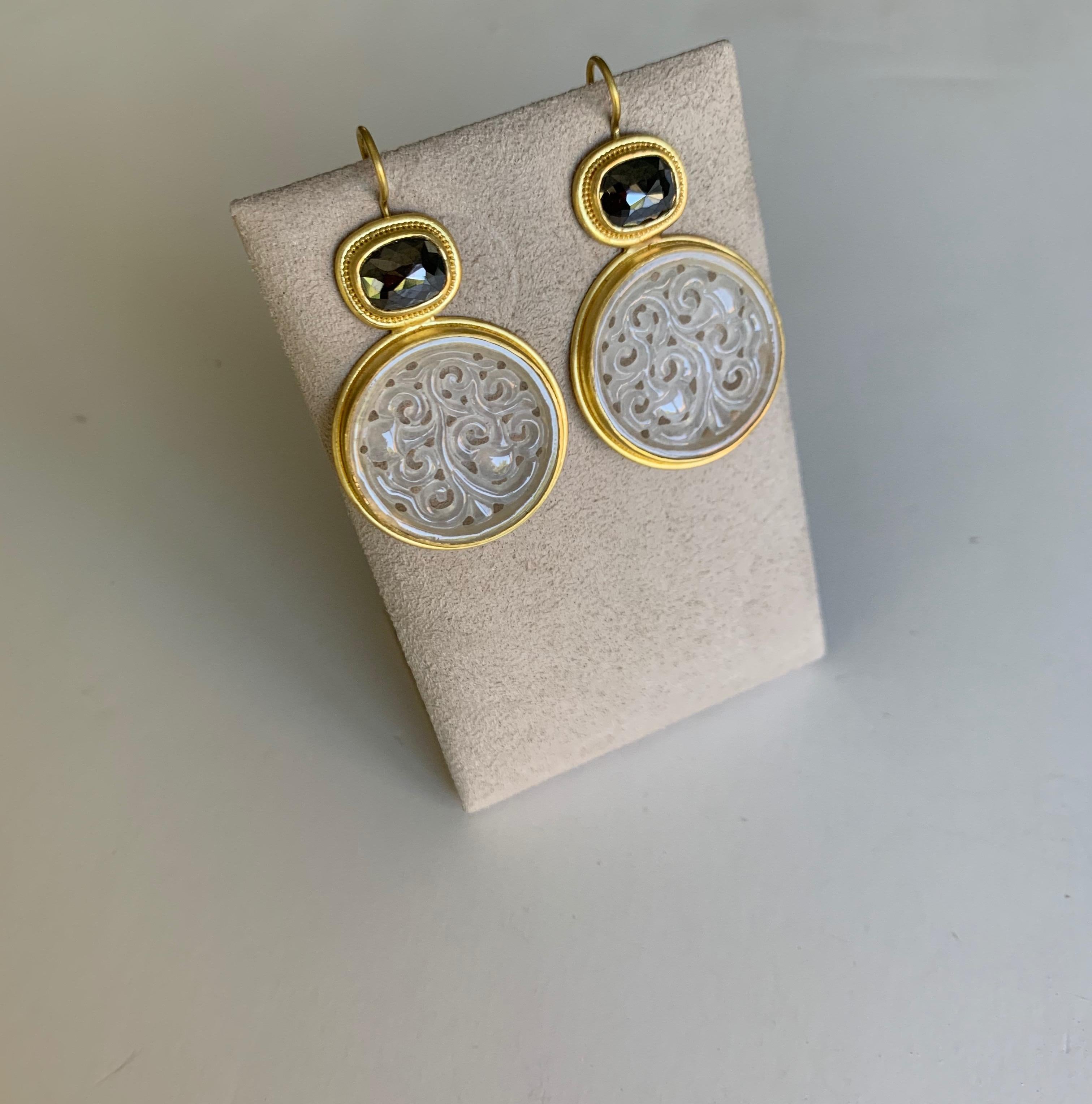 Stunning earrings in delicately carved Icy Jadeite and rose cut black Diamonds, set in 22 Karat gold and enhanced with fine granulation.
The rose cut diamonds are 7 x 9 millimeters and weigh 4.91 carats
The Jadeites are 24mm diameter by 2.5mm