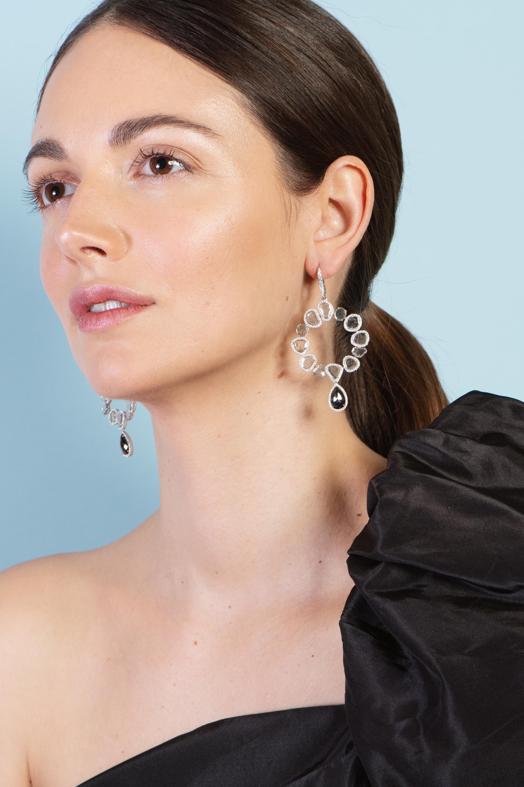 Gross Weight: 16.130 grams 
18 Karat Gold: 14.050 grams 
Total Diamond Weight: 10.40 carats 

Beautiful irregular slices of diamonds are surrounded by smaller diamonds and joined to create these glamorous hoop earrings.  Suspended from a diamond