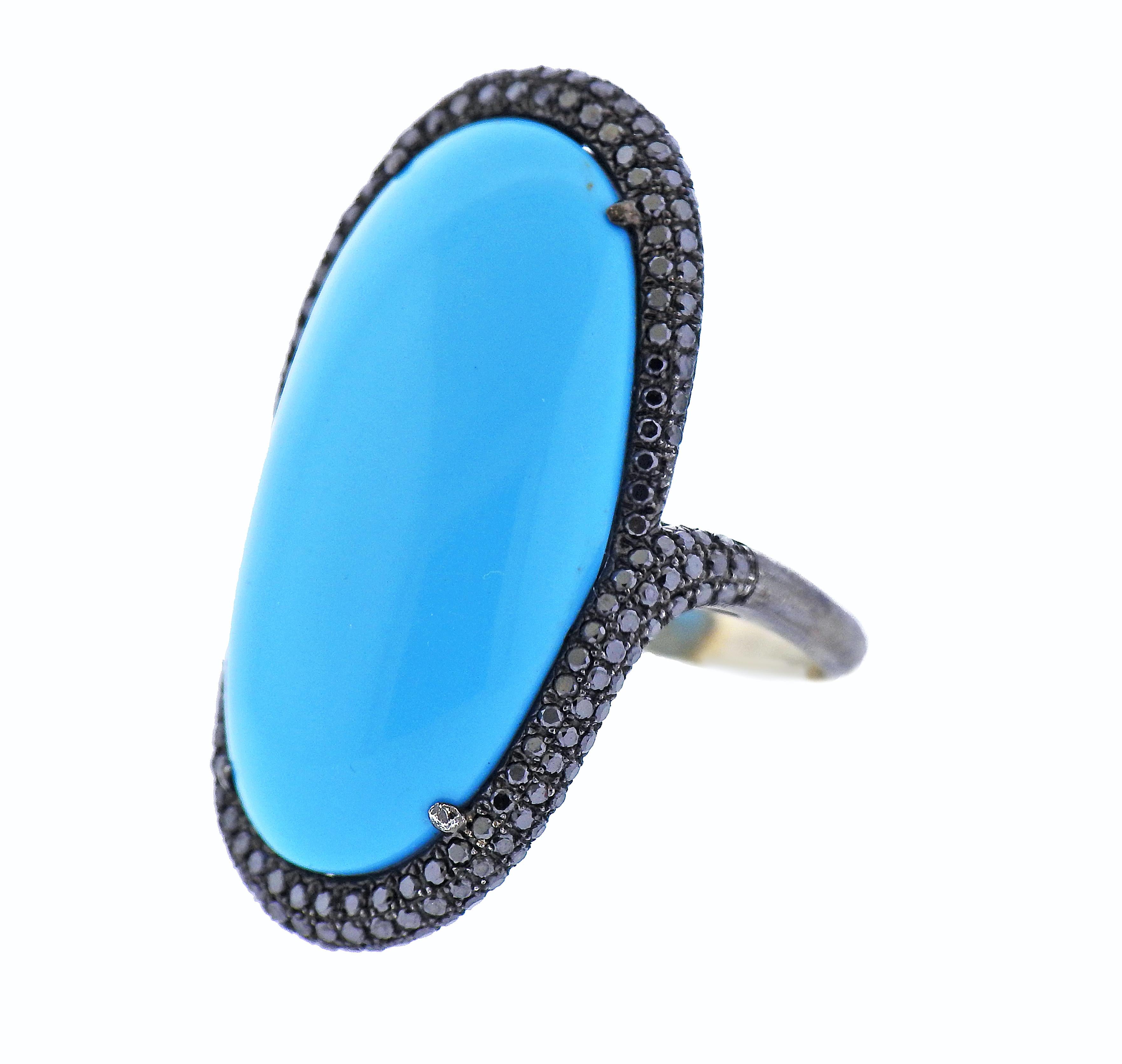 14k blackened white gold cocktail ring, set with a center blue stone (33mm x 18mm), surrounded with approx. 0.60ctw in black diamonds - one stone is missing. Ring size - 9.25, ring top - 38mm x 23mm. Tested 14k. Weight - 12.7 grams.