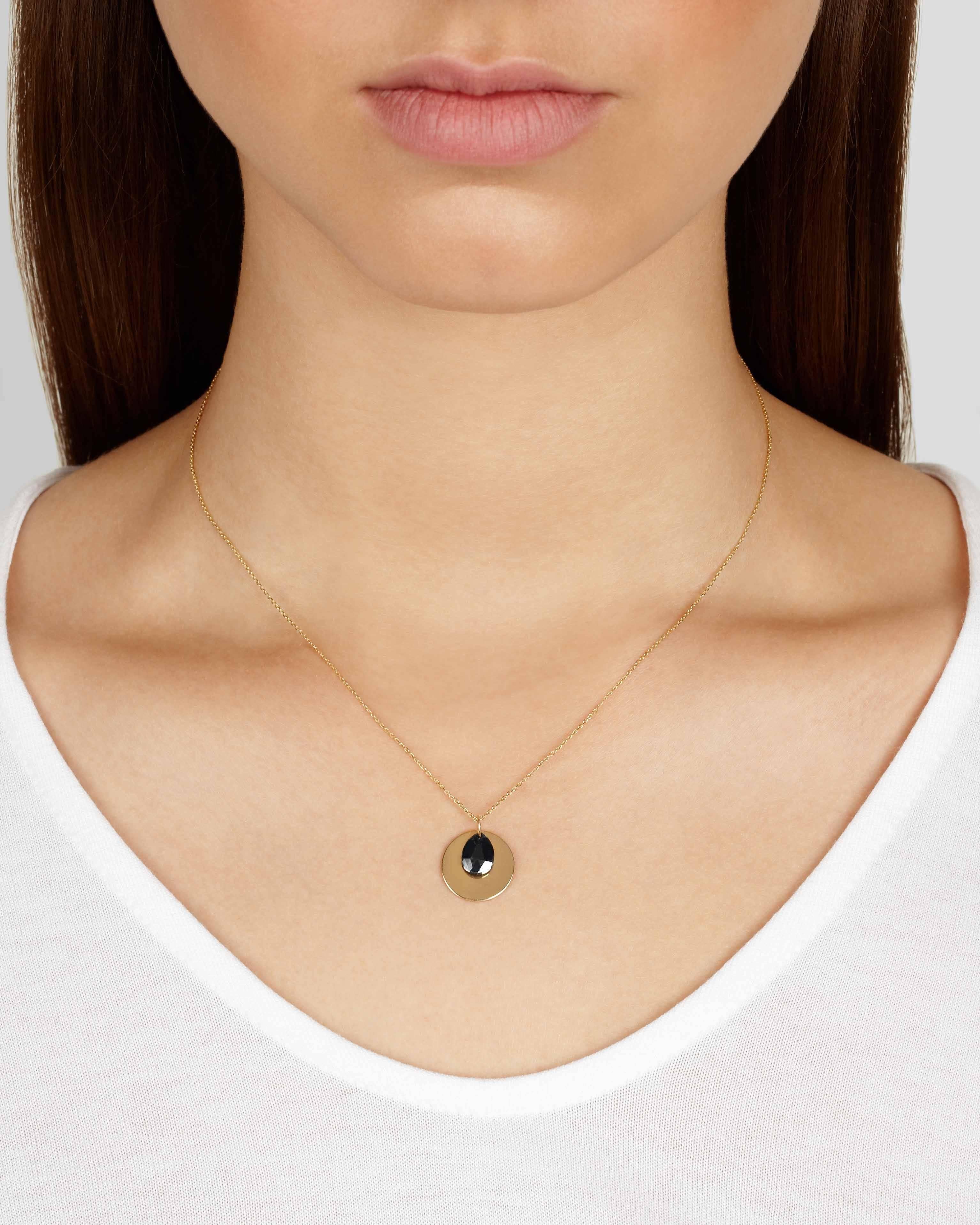 Diese zarte Halskette besteht aus einer massiven 9-Karat-Goldscheibe, die mit einem rustikalen schwarzen Diamanten im Rosenschliff in Birnenform akzentuiert ist. Der Diamant und die Scheiben hängen unabhängig von einer feinen 18-karätigen