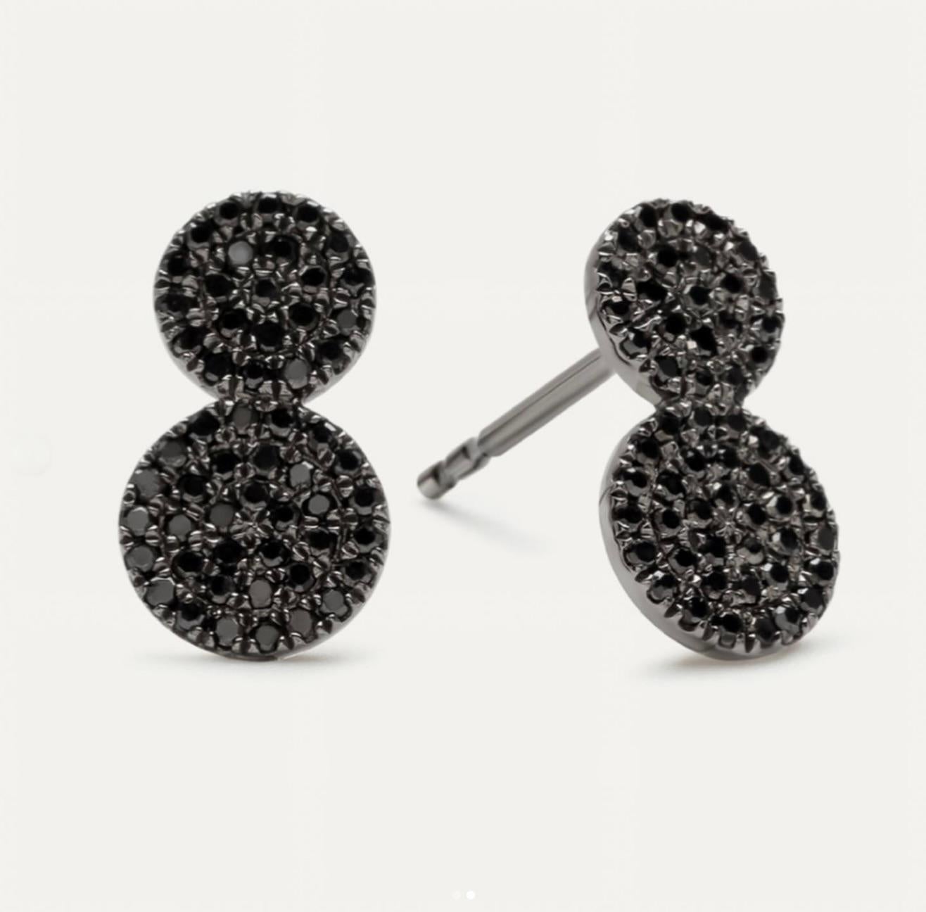 Die schwarzen Diamantohrstecker sind ein fesselnder und zeitgemäßer Ausdruck von Eleganz und Individualität. Diese exquisiten Ohrringe sind mit glänzenden schwarzen Diamanten besetzt, die in zwei kreisförmigen Scheiben gefasst sind. Sie bilden einen