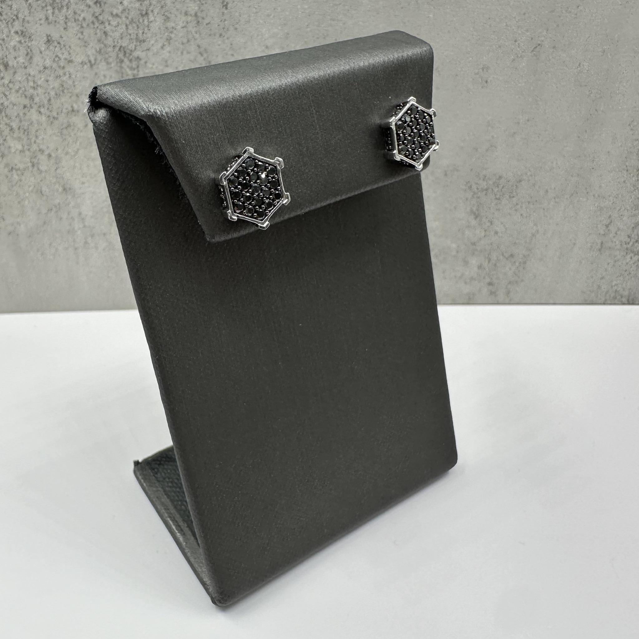 These bold black diamond earrings in sterling silver feature 1 carat total weight of round black diamonds, offering a sleek and modern look. Finished with black rhodium plating for added depth and shine, these earrings make a striking statement