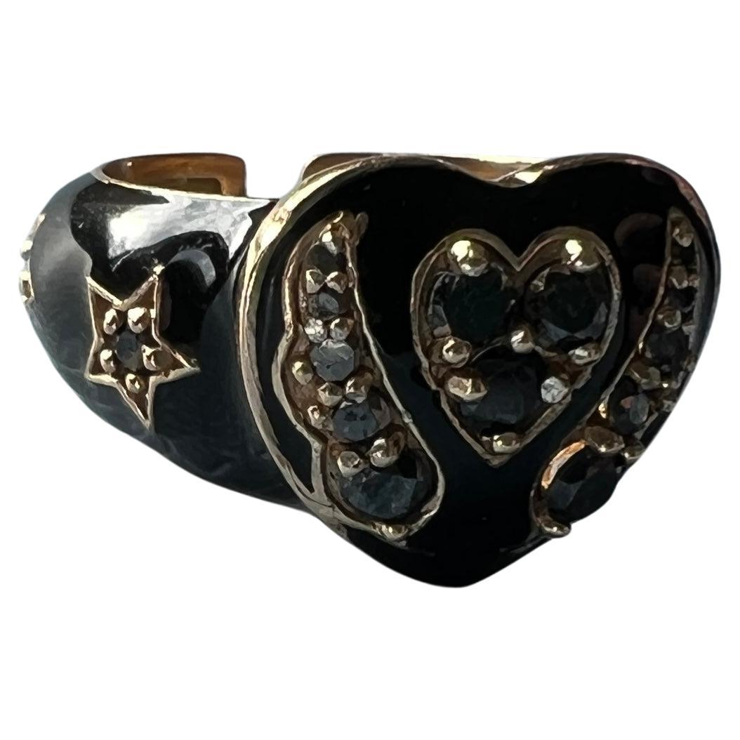 Anello con cuore di diamante nero in oro massiccio 14k con smalto nero - ali d'angelo e dettaglio a stella  J Dauphin
Materiale: Oro massiccio 14k con smalto nero dipinto a mano
A. Stone: Diamanti neri taglio singolo
Progettista: J