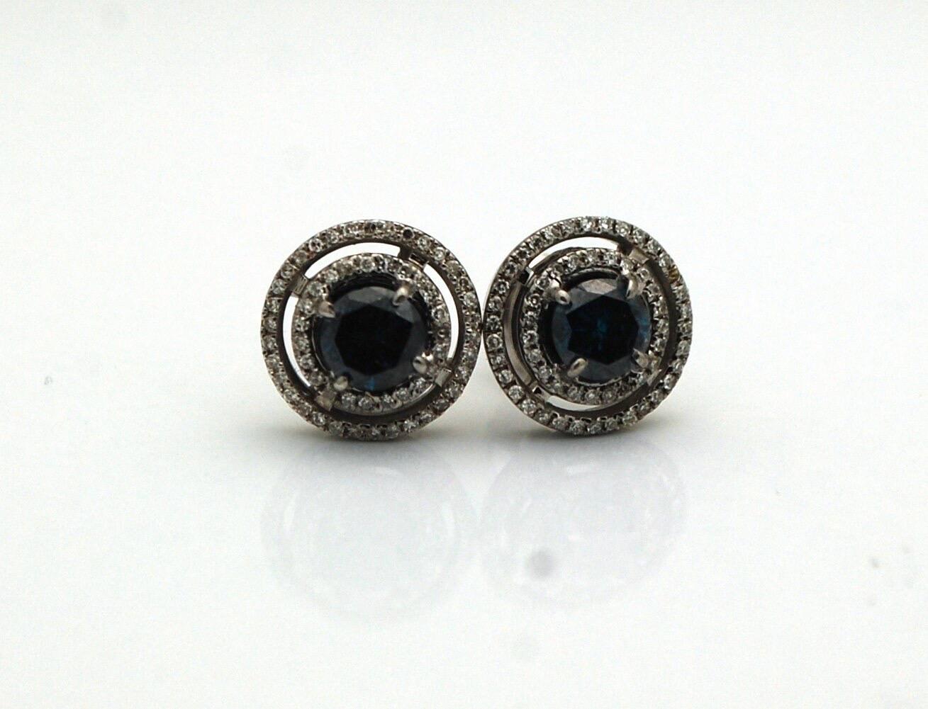 Ohrstecker mit schwarzen Diamanten in der Mitte und weißen Diamanten rundherum aus 18 Karat Weißgold. Die Ohrringe sind modern und passen zu jedem Outfit! Die Mittelsteine sind natürliche schwarze Diamanten von 1 Karat Gesamtgewicht. Die weißen
