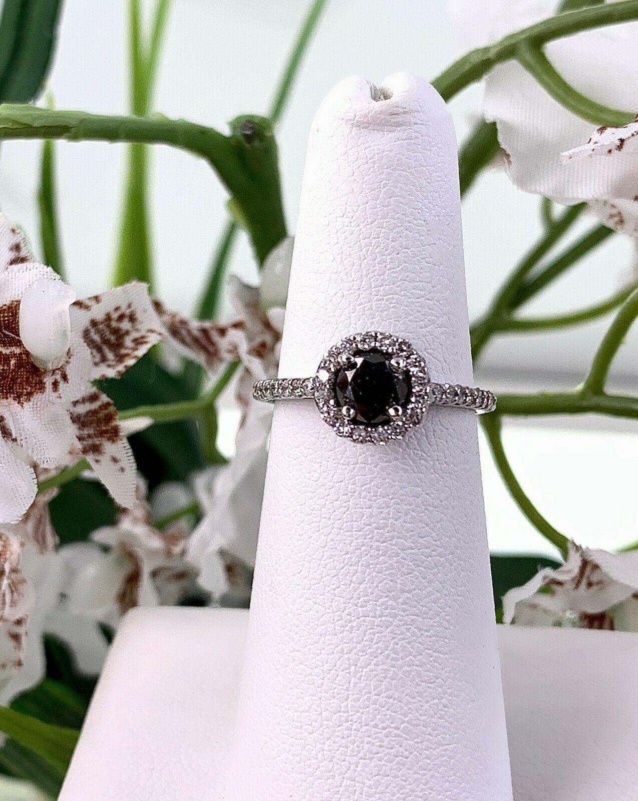 Black Diamond Engagement Ring
Style:  Diamond Halo Ring
Metal:  14K White Gold
Size / Measurements:  5, sizable
TCW:  1.32 Carats Total
Main Diamond:  0.68 Carat Round Brilliant Cut
Color & Clarity:  Black Opaque, Natural Origin
Accent Diamonds:  54