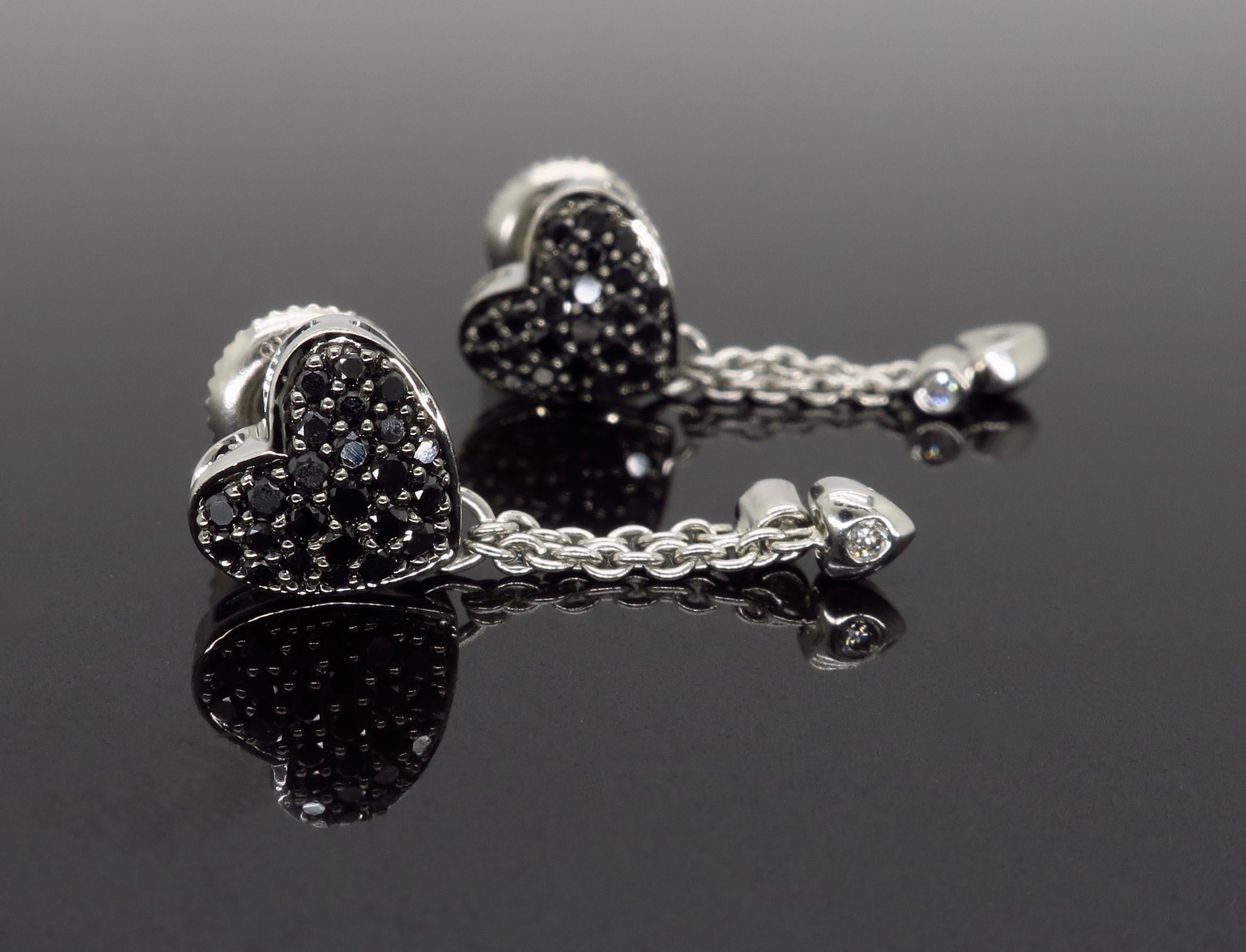 Heart shaped black and white diamond earrings crafted in 14K white gold.

Diamond Carat Weight: Approximately .24CTW 
Diamond Cut: Round Brilliant Diamonds
Color: Black Diamonds with 4 additional Round Brilliant Cut Diamonds with average H-J