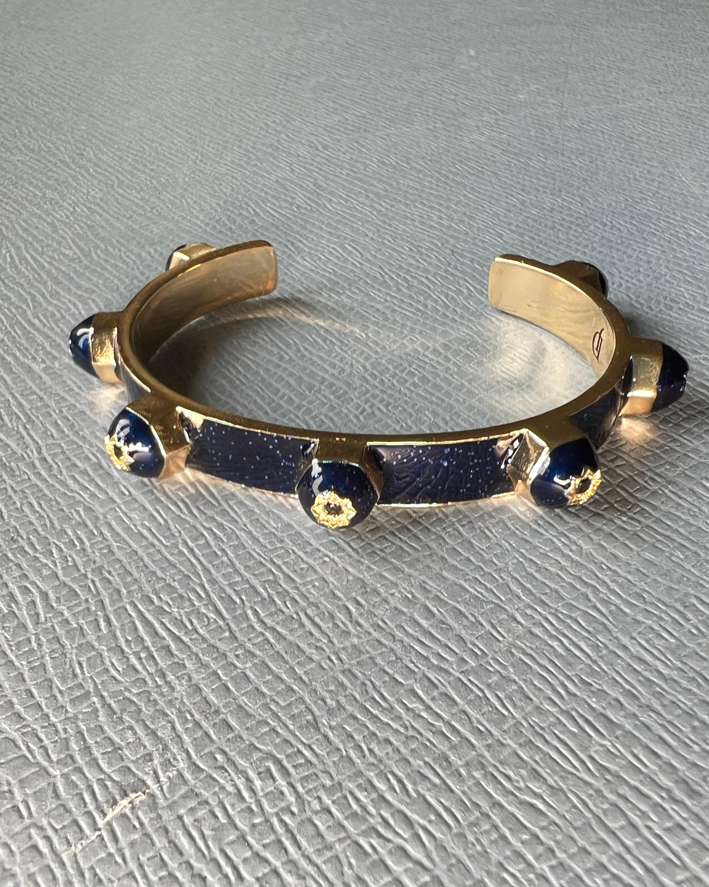 7 pcs Black Diamond Midnight Blue Enamel Stud Cuff Bracelet
Designer : J DAUPHIN

Mélange frappant de symbolisme et d'artisanat moderne, ce bracelet manchette en diamants noirs de J DAUPHIN est conçu pour se démarquer. Présentant sept diamants noirs