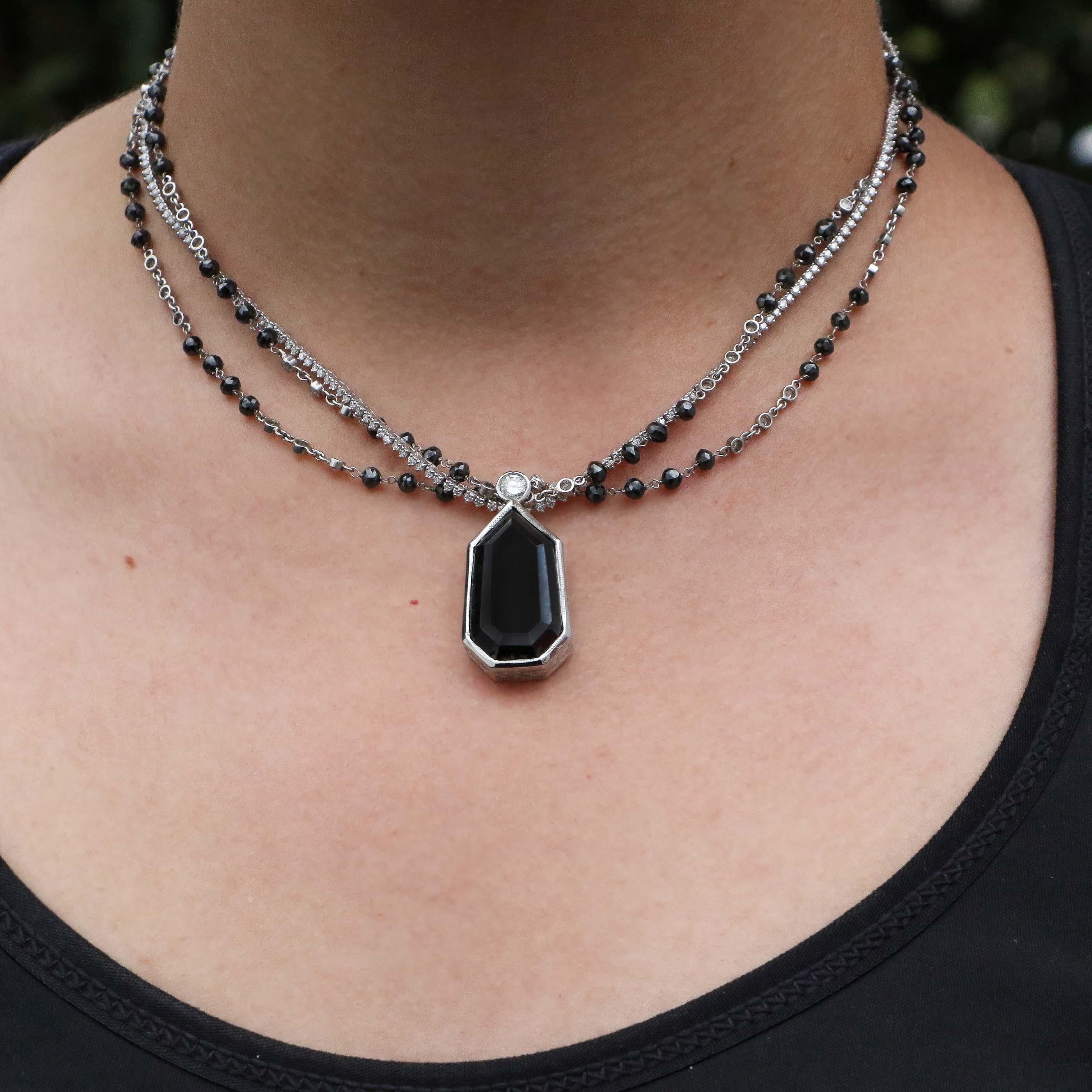 Apart of our hand-curated collection of rare and unique diamonds. This pendant boldly presents a 24+ carat black diamond at its center. The pendant has a latch allowing it to be attached to an assortment of chains and necklaces. It comes with two