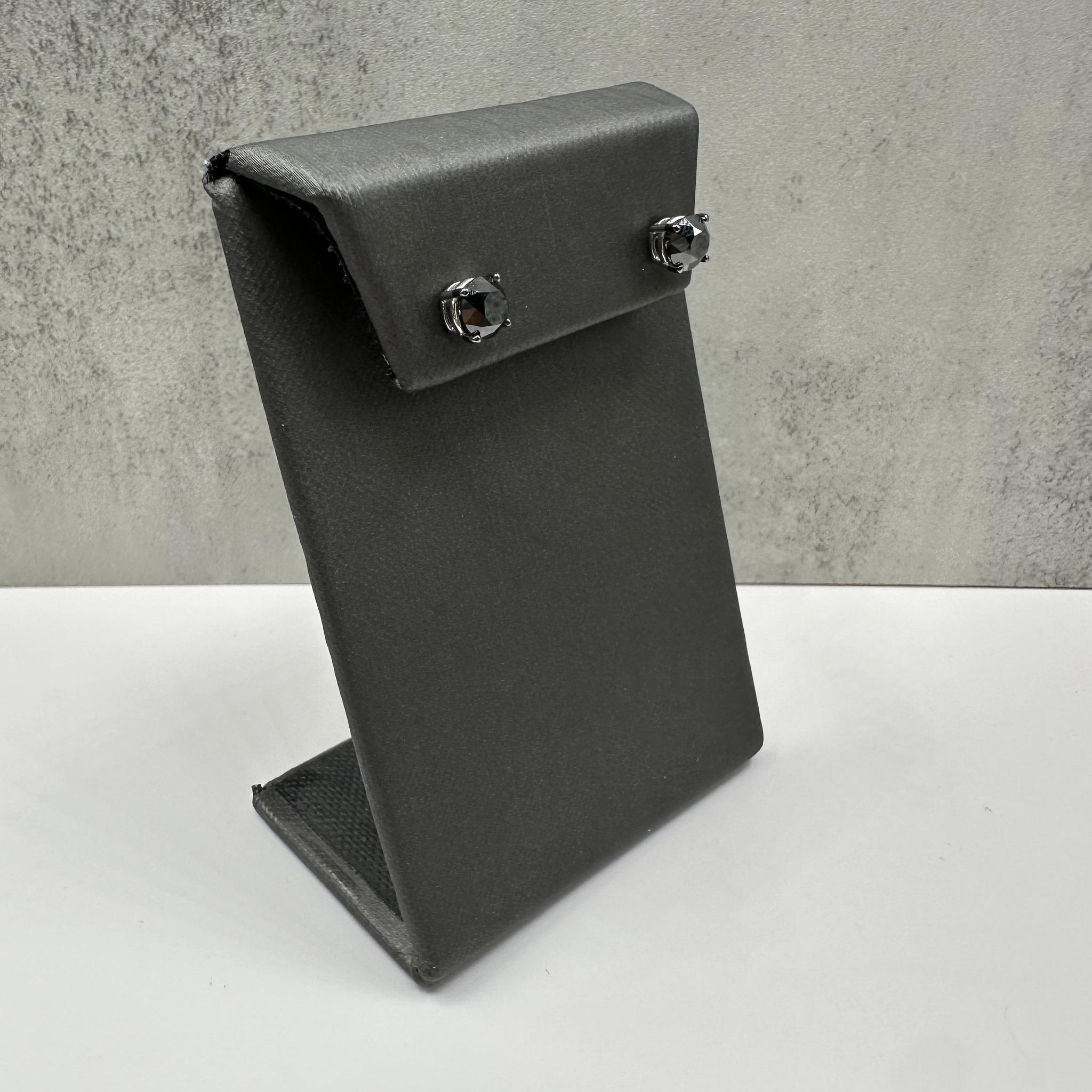 Ces boucles d'oreilles audacieuses en or blanc 10 carats sont composées de diamants noirs ronds d'un poids total de 2 carats, sertis dans une monture panier classique à 4 branches. Les griffes sont plaquées de rhodium noir, ce qui rehausse le ton