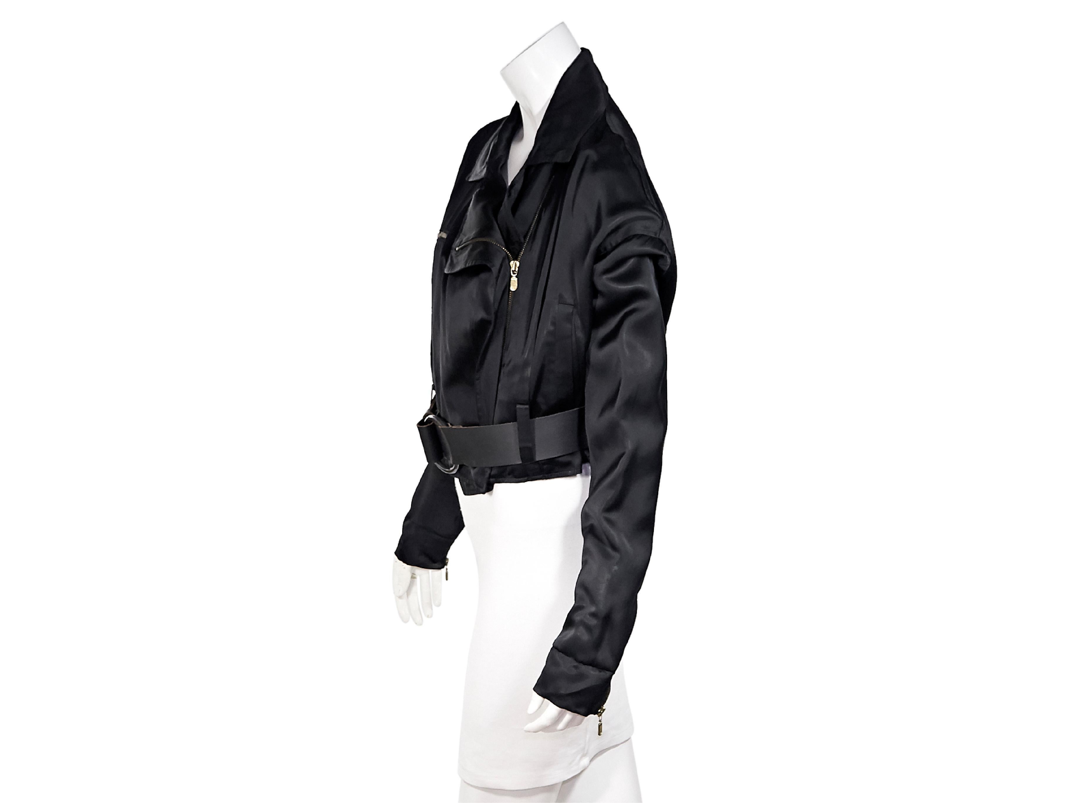 Product details:  Black silk cropped moto jacket by Dolce & Gabbana.  Spread collar.  Long sleeves.  Zip cuffs.  Concealed asymmetrical zip-front closure.  Chest zip pocket.  Adjustable belted waist.  Goldtone hardware.  Label size IT 46.  38