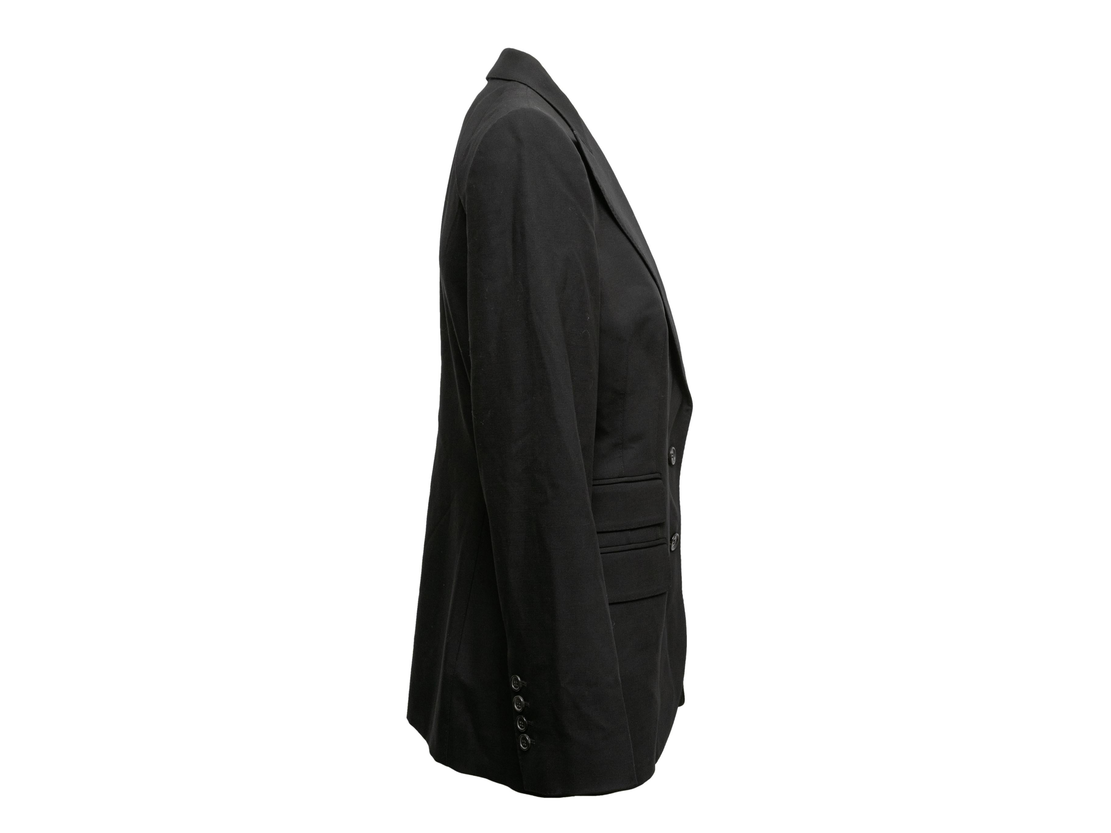 Black peaked lapel blazer by Dolce & Gabbana. Four pockets. Button closures at front. 36