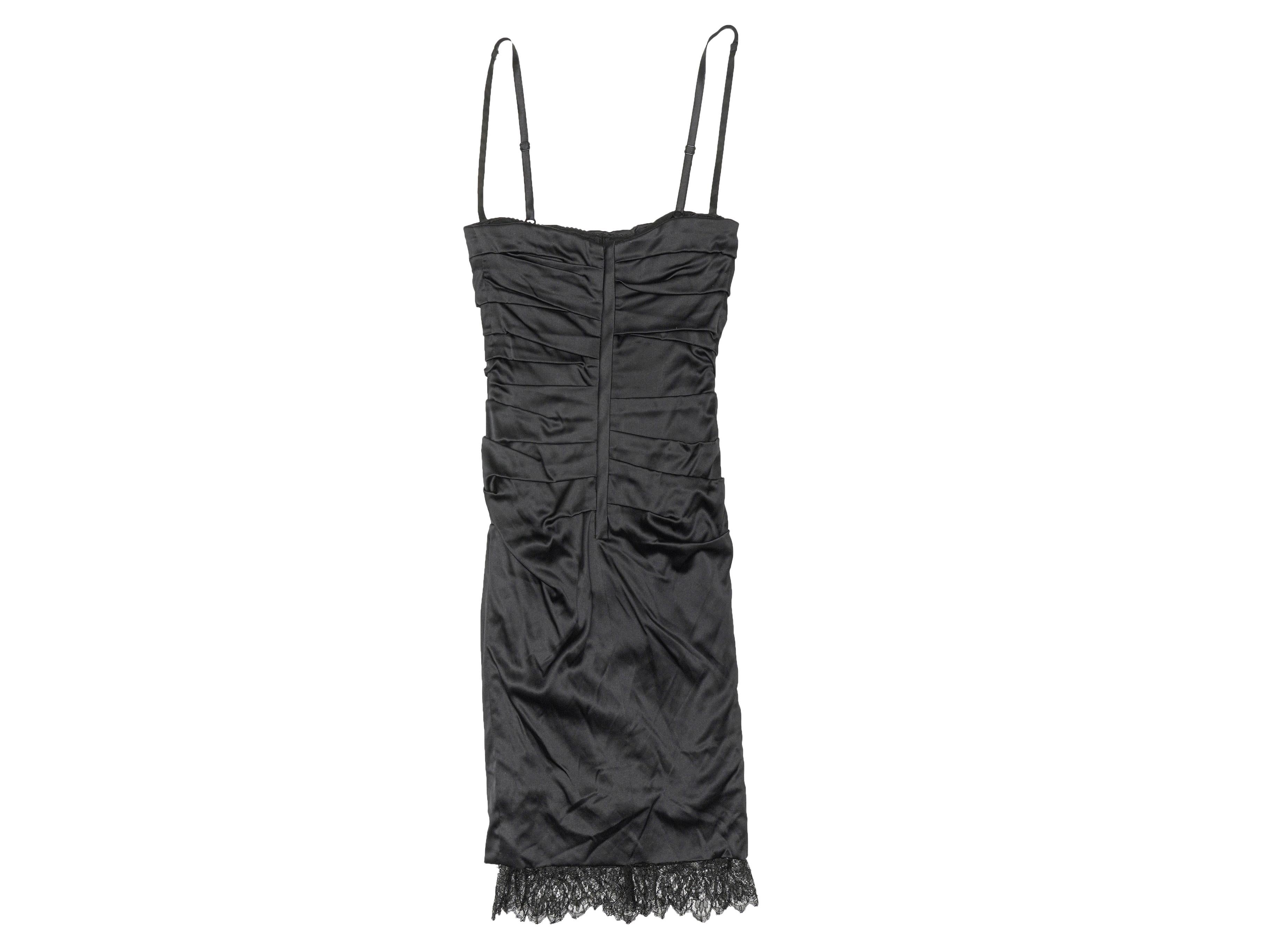 Product Details: Black silk sleeveless ruched dress by Dolce & Gabbana. Narrow straps. Lace trim at hem. Zip closure at center back. 23