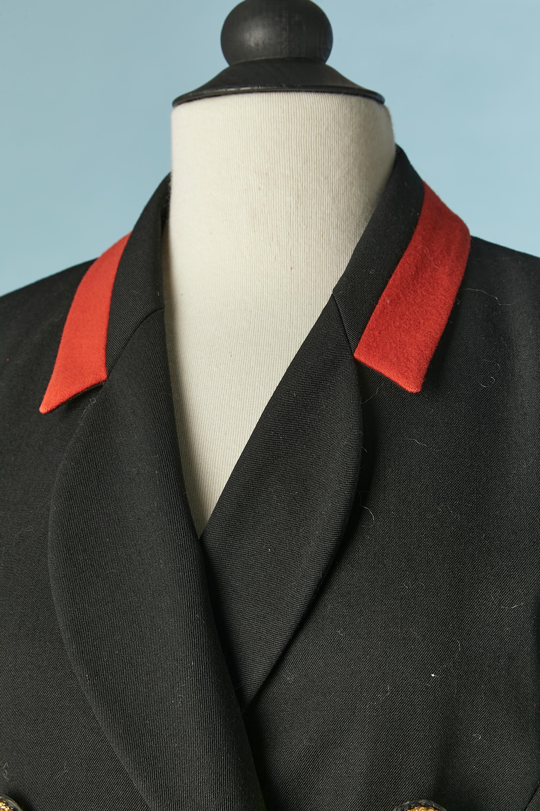 Black double-breasted jacket with gold buttons and red details . Main fabric: wool. Lining: probably acetate or rayon. 
Shoulder pads. Cut-work. 2 split in the bottom front and 3 splits in the back 
SIZE 40 (Fr) 10 (US) L 