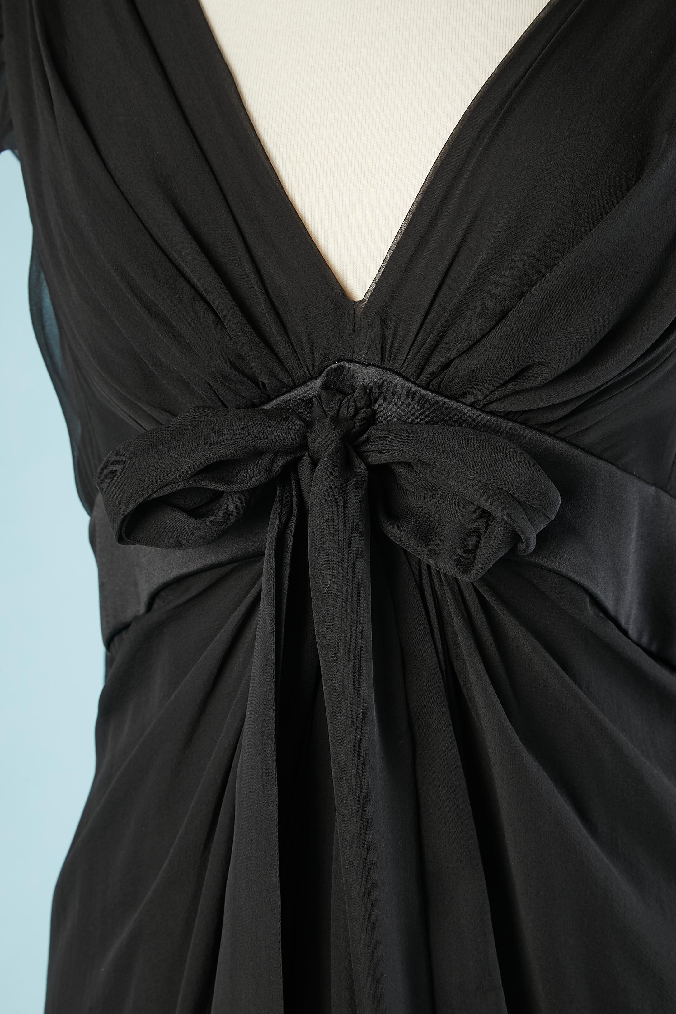 Black drape evening dress in silk chiffon with bow in the middle front.Black satin ribbon under the bust. Bow behind the arms.Zip in the middle back with hook&eye. Shorter in the front (110 cm) than in the back ( 150 cm) 
SIZE 40 ( M) 