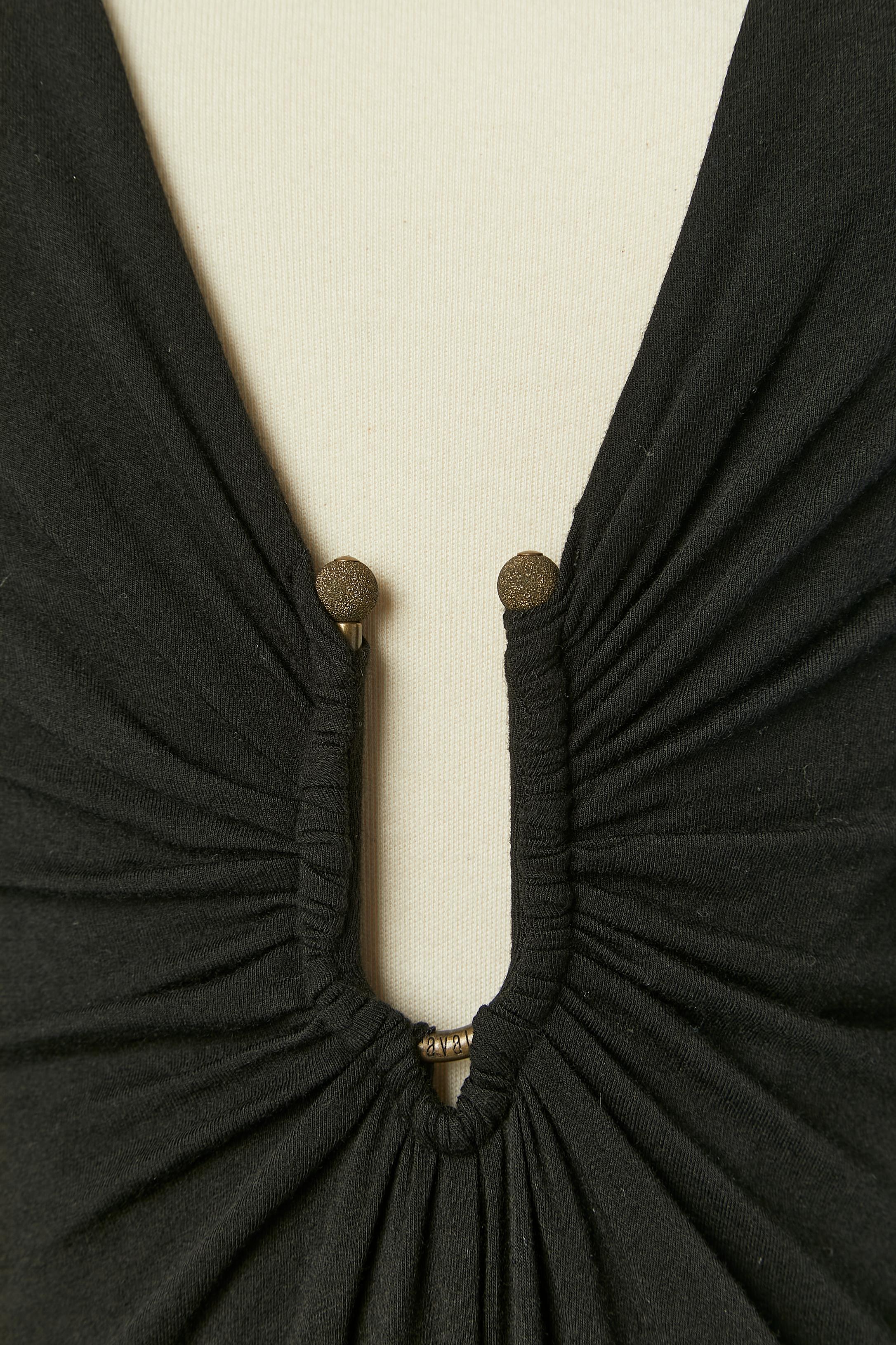 Black draped jersey cocktail dress with deep V neckline and a branded metalic sort of buckle on the middle front. 
Fabric composition: 80% rayon, 15% wool, 5% elastane. 
Elastic band at the end of the sleeves. 
Authenticity hologram. 
SIZE 44 (It)