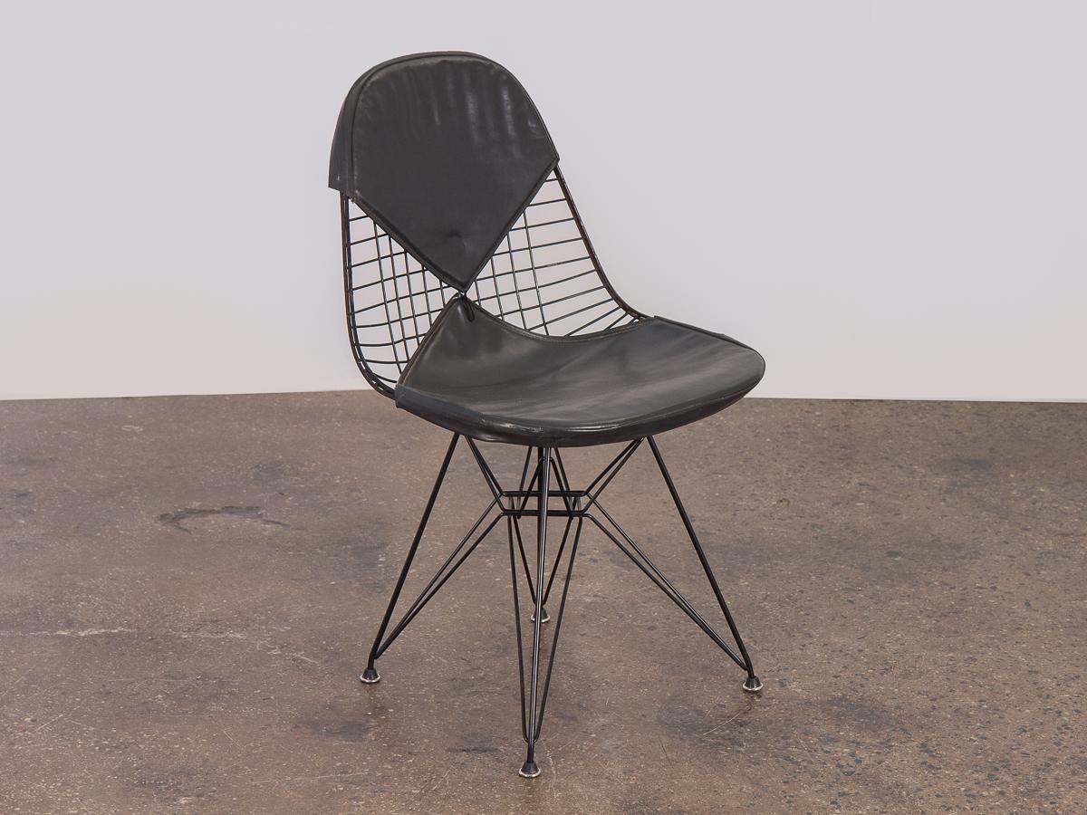 Superbe chaise filaire Eames noire classique sur une base eiffel noire avec la housse bikini pour Herman Miller. La housse de bikini n'a pas de bouton et présente une déchirure dans le coin avant droit, mais elle est douce et souple au toucher. Une