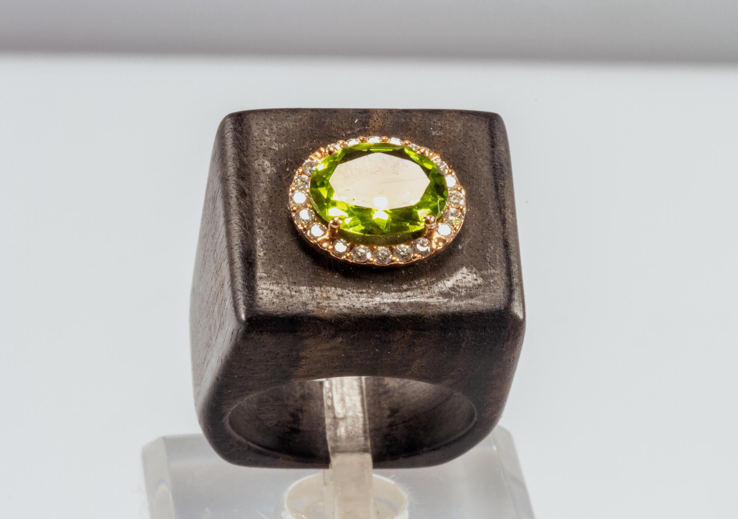 Very original ring in black ebony wood on which a green peridot gem surrounded by diamonds has been set.
The peridot and diamonds are set on a 9 kt rose gold element.
Jewel with a unique design, handmade by Italian artisans with natural