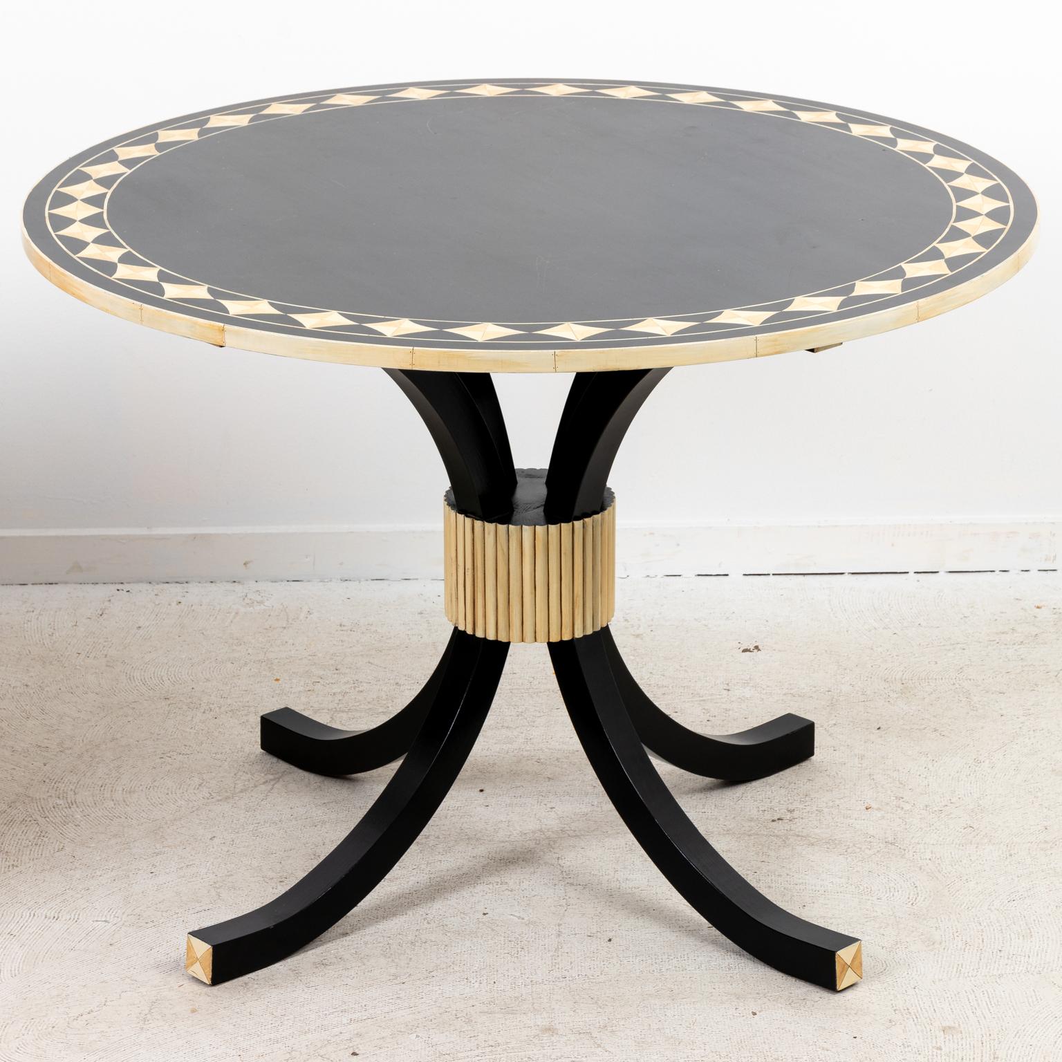 Circa 1990s Anglo Indian style painted black ebony round table with faux bone and ivory detail. The table also features lozenge shaped trim on the tabletop. Made in the United States. Please note of wear consistent with age.