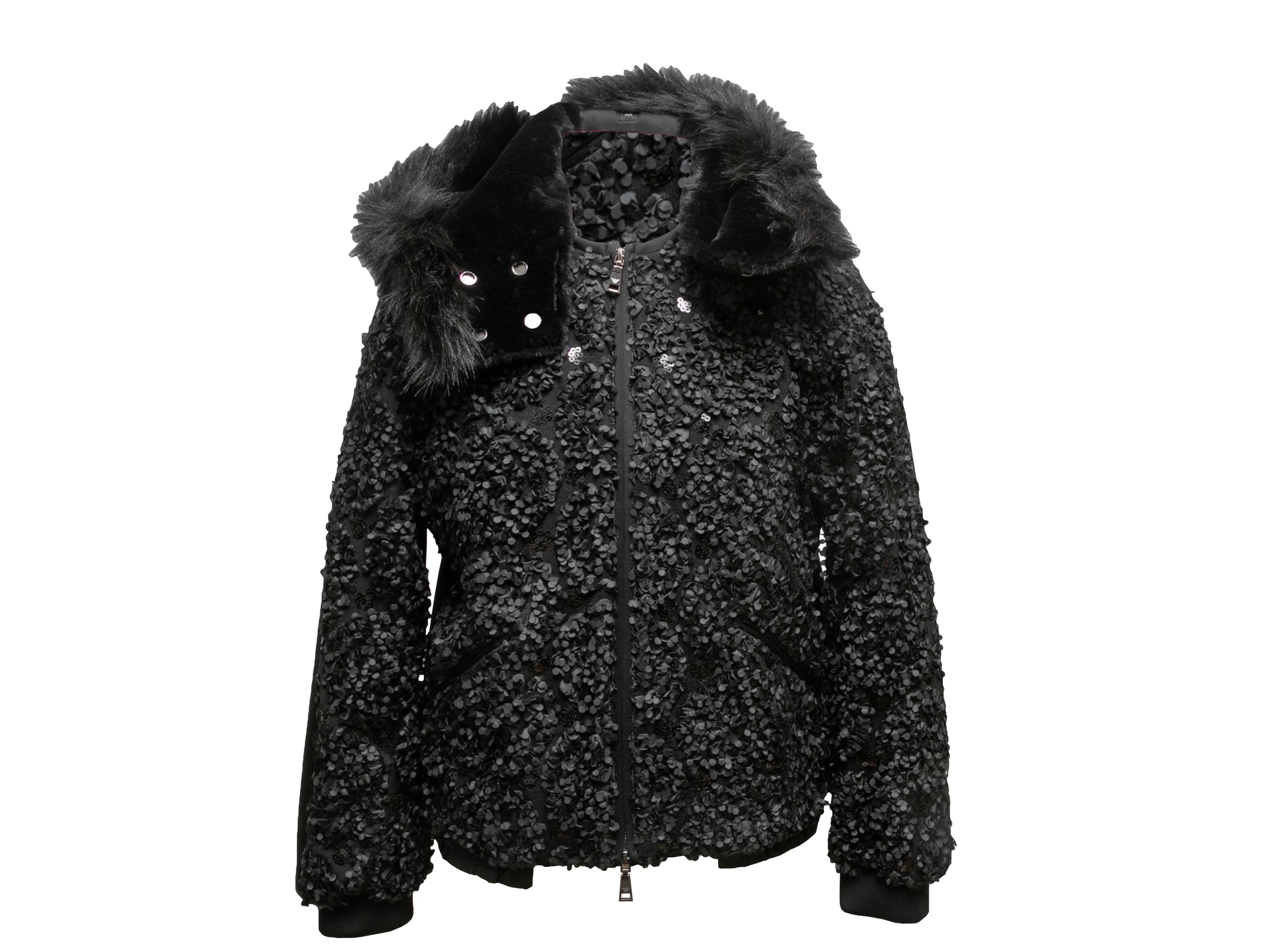 Product Details: Black textured front hooded zip jacket by Emporio Armani. Faux fur trim at hood. Dual hip pockets. Zip closure at center front. 38
