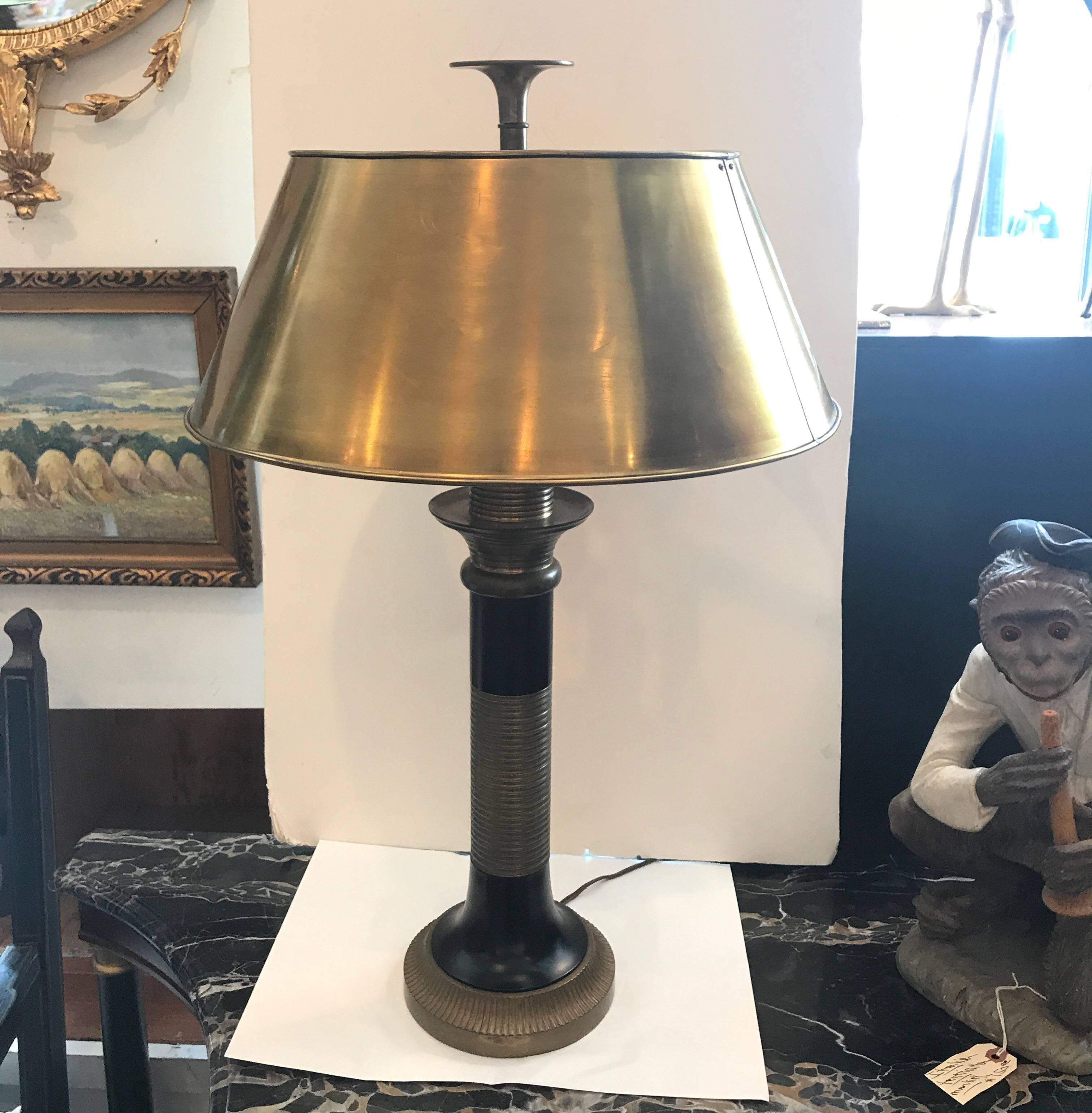 A brass and black enamel table lamp by Chapman. The brass shade supported by a ribbed brass column base with black enameling. The lamp takes two standard base bulbs.