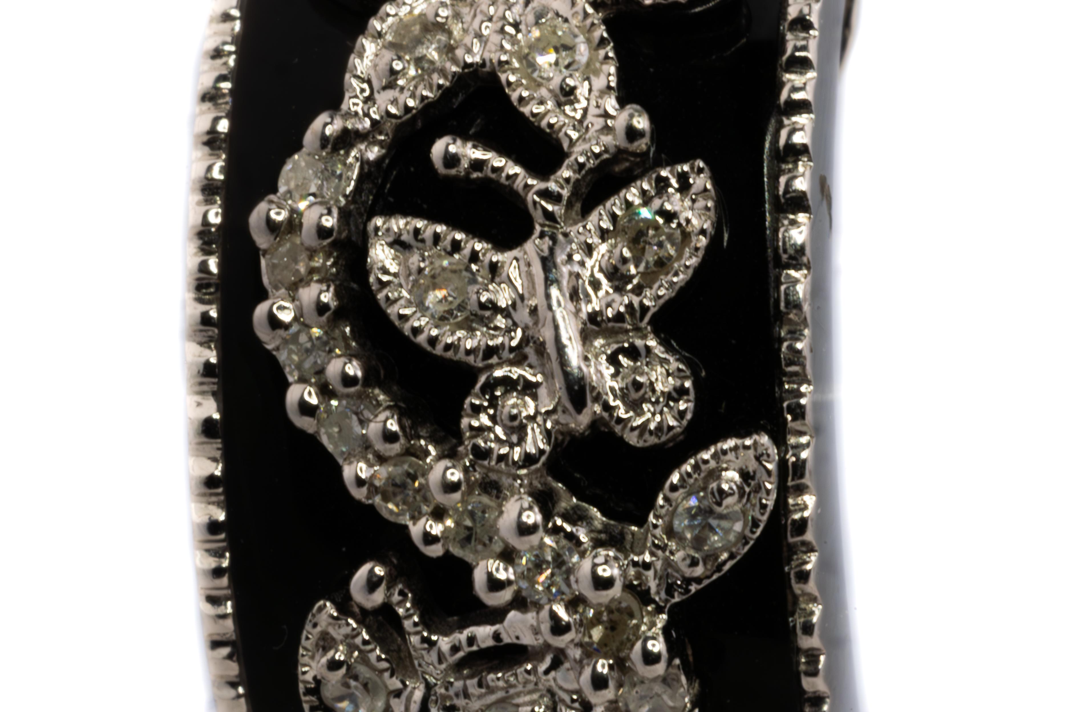 Black Enamel and Diamond Butterfly Motif Earrings

Description:
A charming pair of earrings featuring a delicate garden of diamond-set butterflies and floral motifs, gracefully set against a backdrop of glossy black enamel. The design is framed with