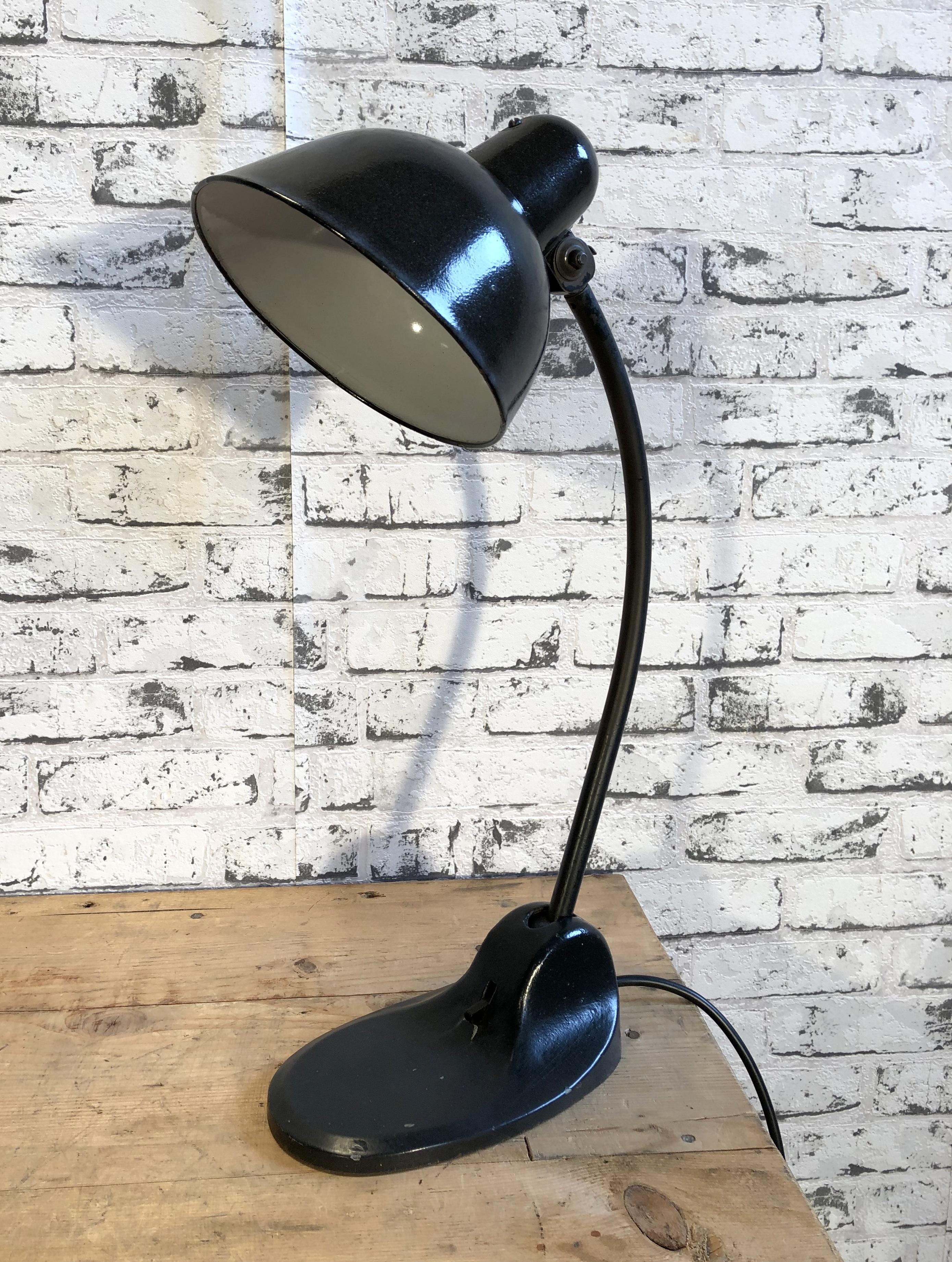 Black Industrial table lamp made by Siemens during the 1930s.It features black enamel shade, white interior, black iron base with original switch and arm with two adjustable joints. Original socket for E 27 lightbulbs. Fully functional.
