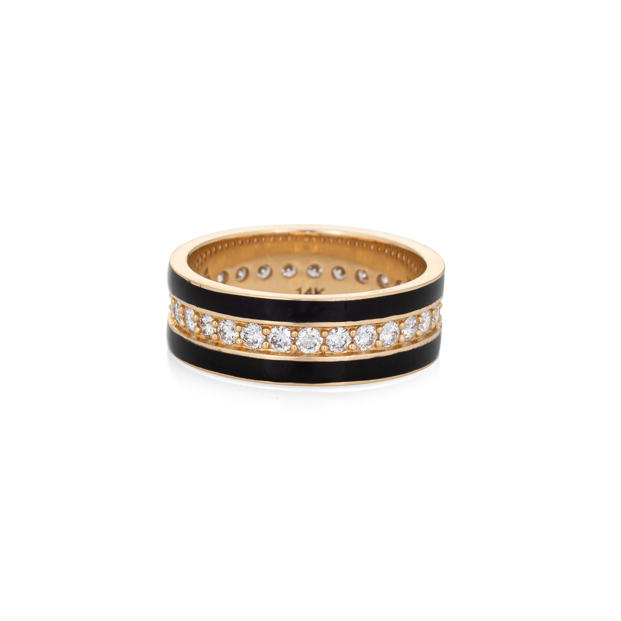 Stylish black enamel diamond eternity ring crafted in 14 karat yellow gold. 

Round brilliant cut diamonds total an estimated 0.21 carats (estimated at H-I color and SI1-2 clarity). 

With a strand of diamonds to the center and framed with black