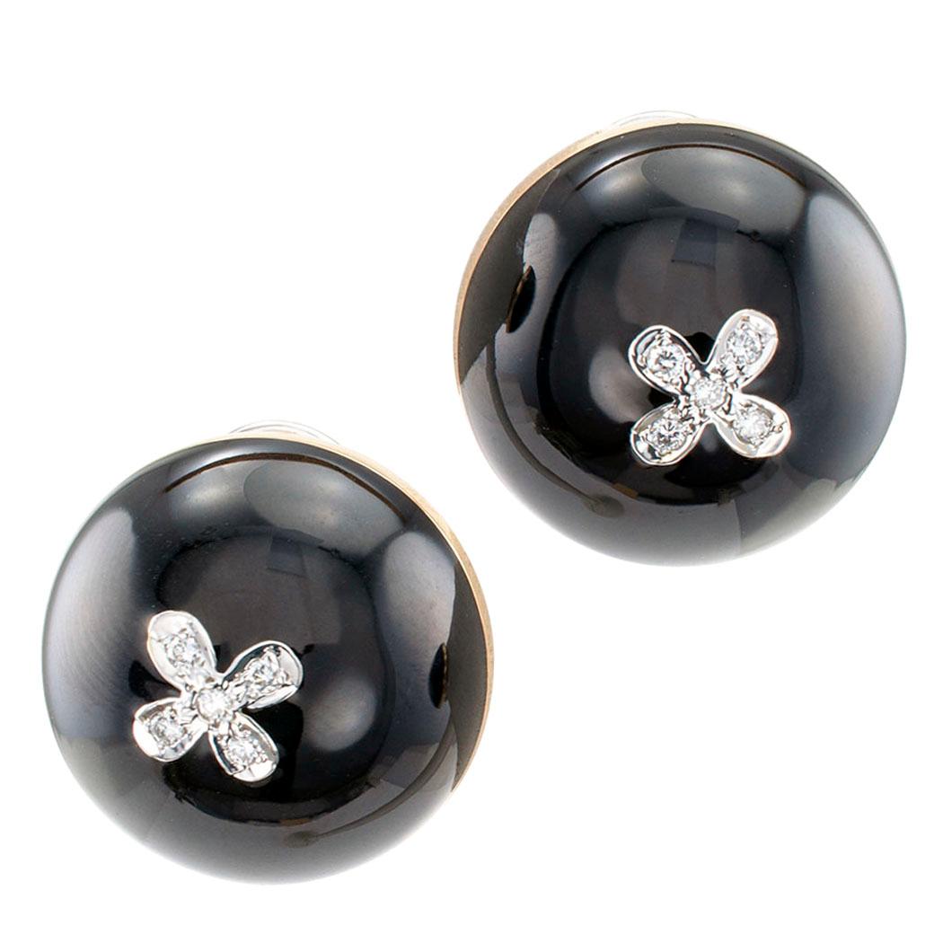 Black enamel and diamond gold button earrings circa 1980. The domed designs center upon a floret motif set with diamonds, all totaling approximately 0.10 carat, contrasted with black enamel, mounted in 14-karat gold. This is a comfortable, very