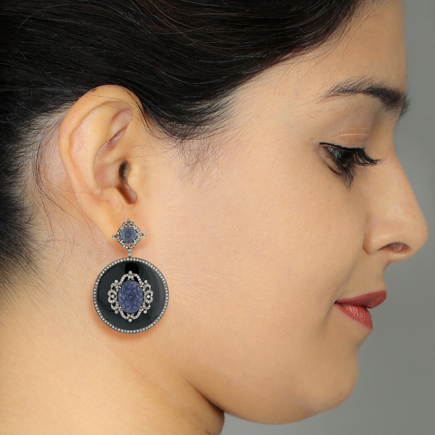 Round Black Enamel Earring with Hand Craved Sapphire and Diamonds motif in Gold and Silver is super pretty and attractive.

Closure: Push Post

18KT Gold: 1.83gms
Diamond: 2.79cts
SiIver: 30.82gms
Sapphire: 21.8cts
