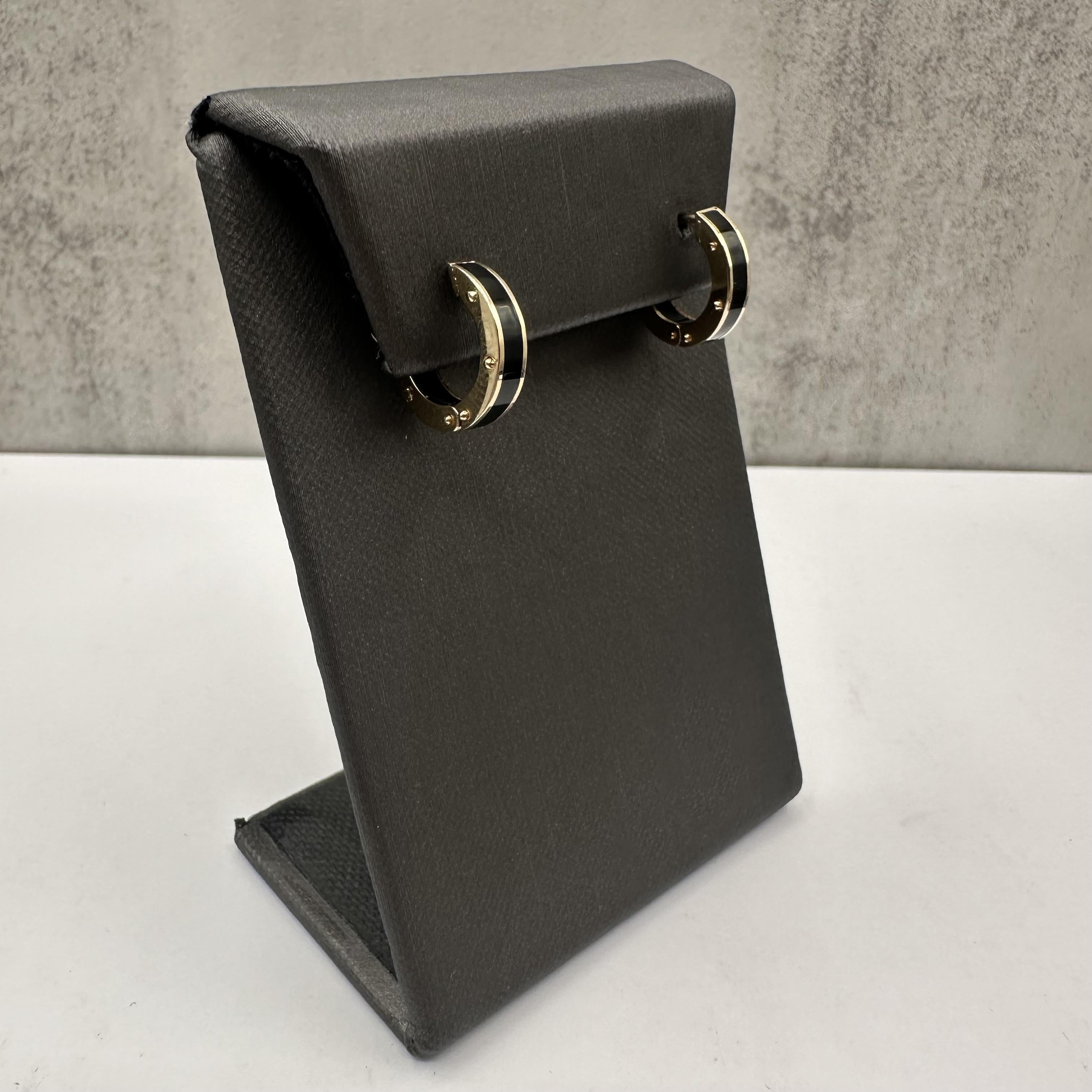 Add a modern touch of elegance to your collection with these stylish Black Enamel Huggies, crafted in 14kt Yellow Gold. Featuring a sleek black enamel inlay, these huggie-style earrings have a 4.3mm width and a 14.7mm outer diameter, making them the