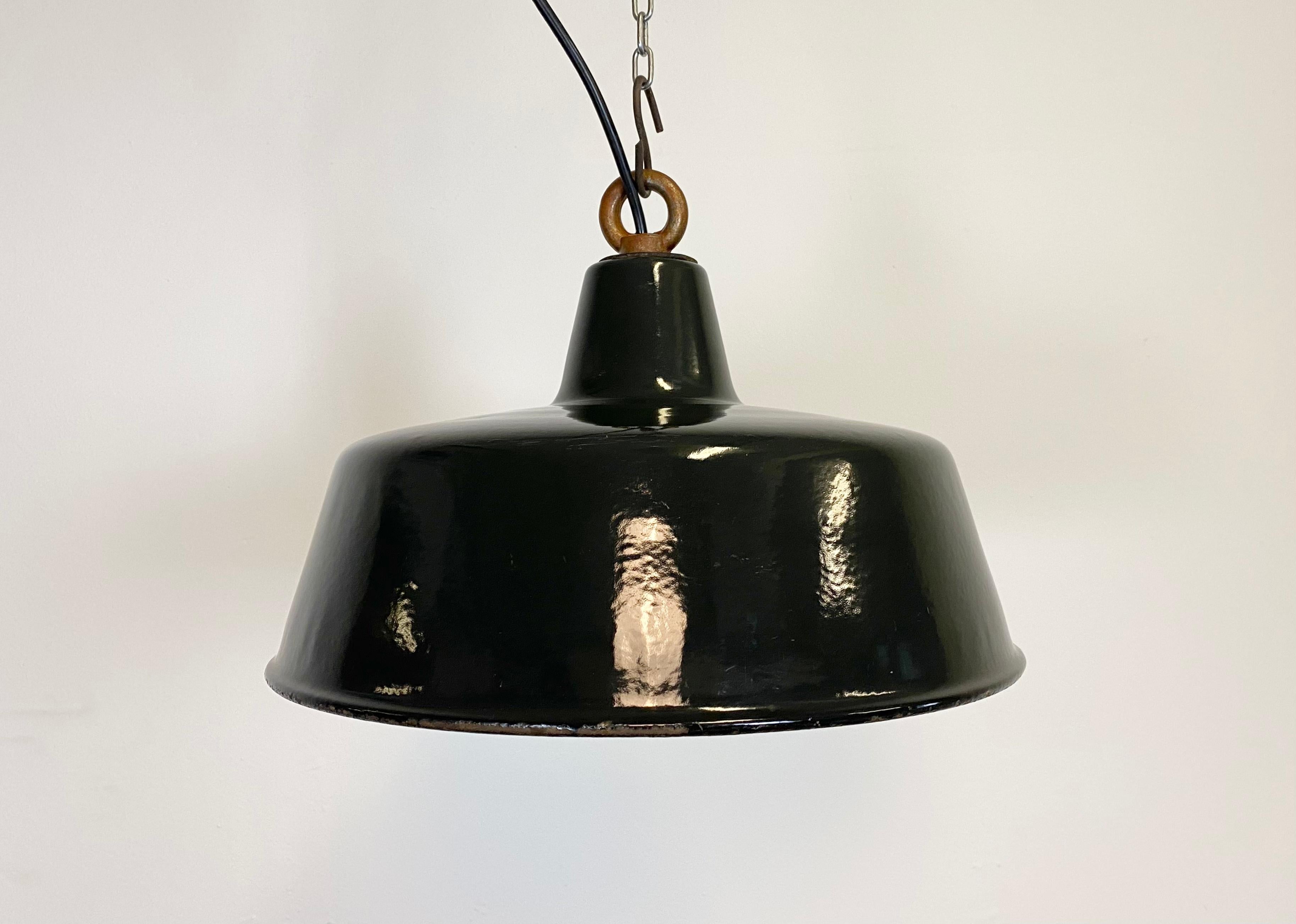 Industrial black enamel pendant lamp with white interior. Iron top. Manufactured during the 1930s. New porcelain socket for E 27. New wire.