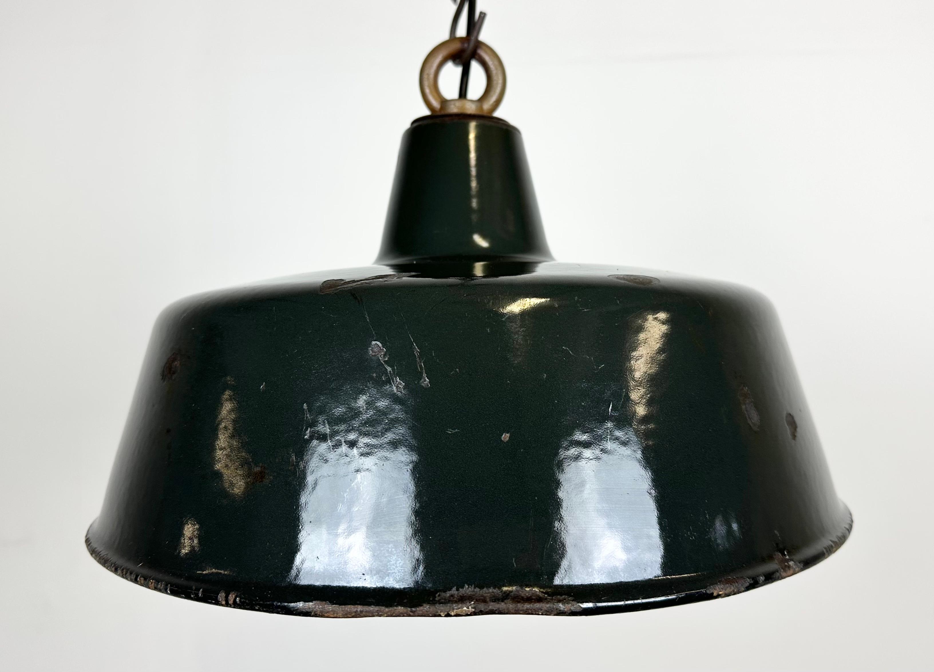 Industrial black enamel pendant lamp with white interior. Iron top. Manufactured during the 1950s. New porcelain socket rerquires E 27/ E26 light bulbs. New wire.