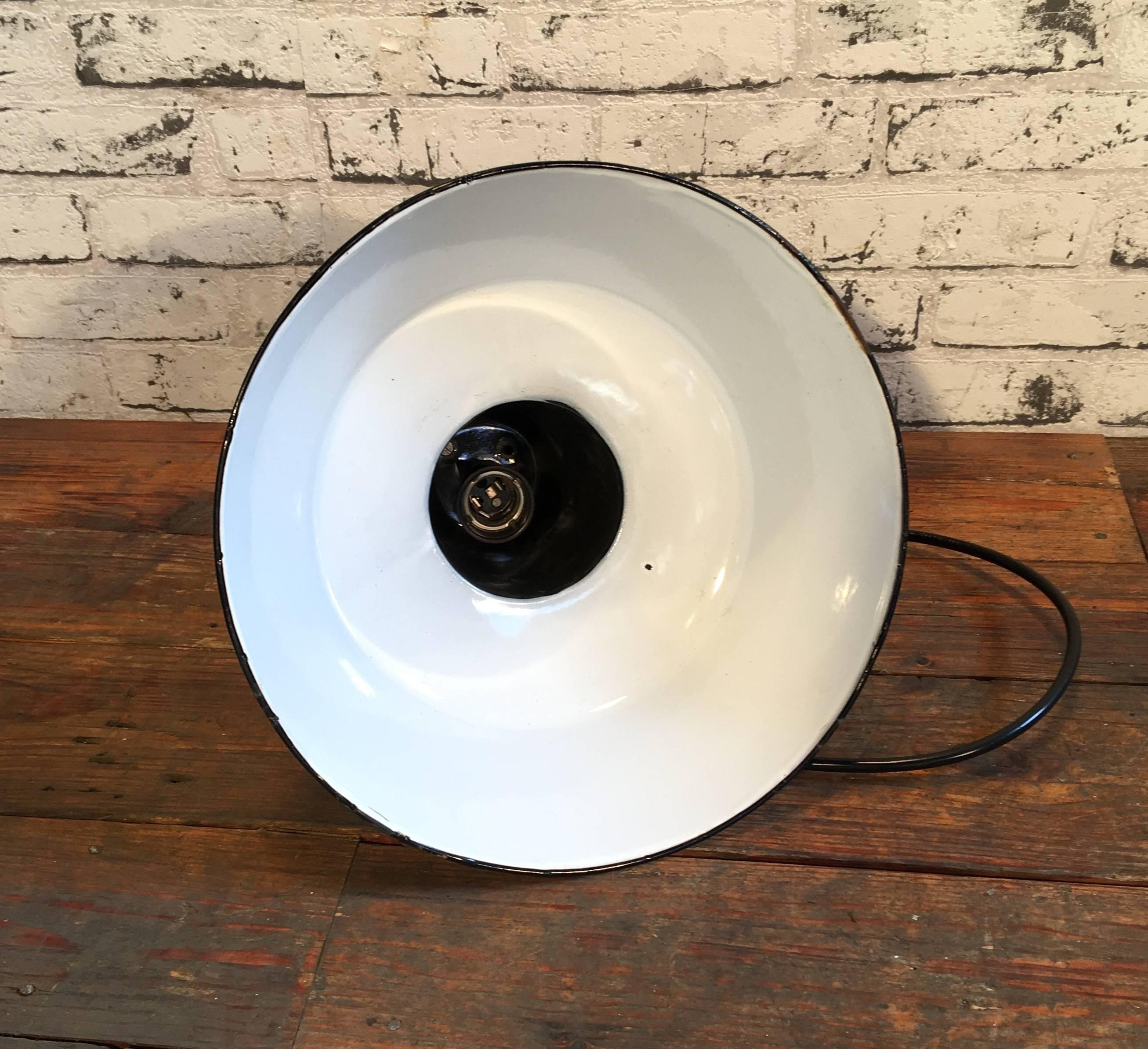 Pendant lamp in bauhaus style from former Czechoslovakia, previously used in a factories.
Made from enameled metal. Black outside, white interior. Cast iron top.
New porcelain socket for  E27 lightbulbs and wire. Weight 1.5 kg.