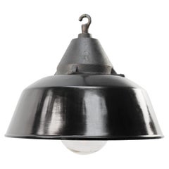 Lampes suspendues en fonte industrielle émaillée noire et verre transparent.