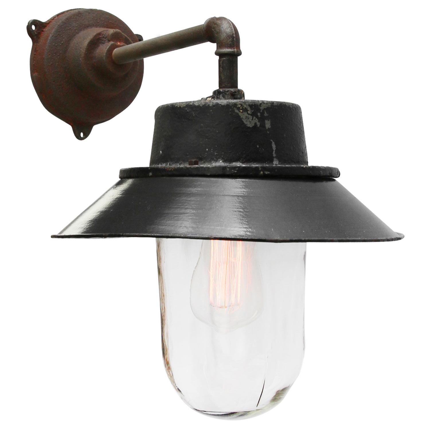 Black enamel industrial wall light. 
Black painted cast iron top.
Clear glass. 

Diameter cast iron wall piece: 12 cm. Three holes to secure.

Weight: 6.5 kg / 14.3 lb

Priced per individual item. All lamps have been made suitable by