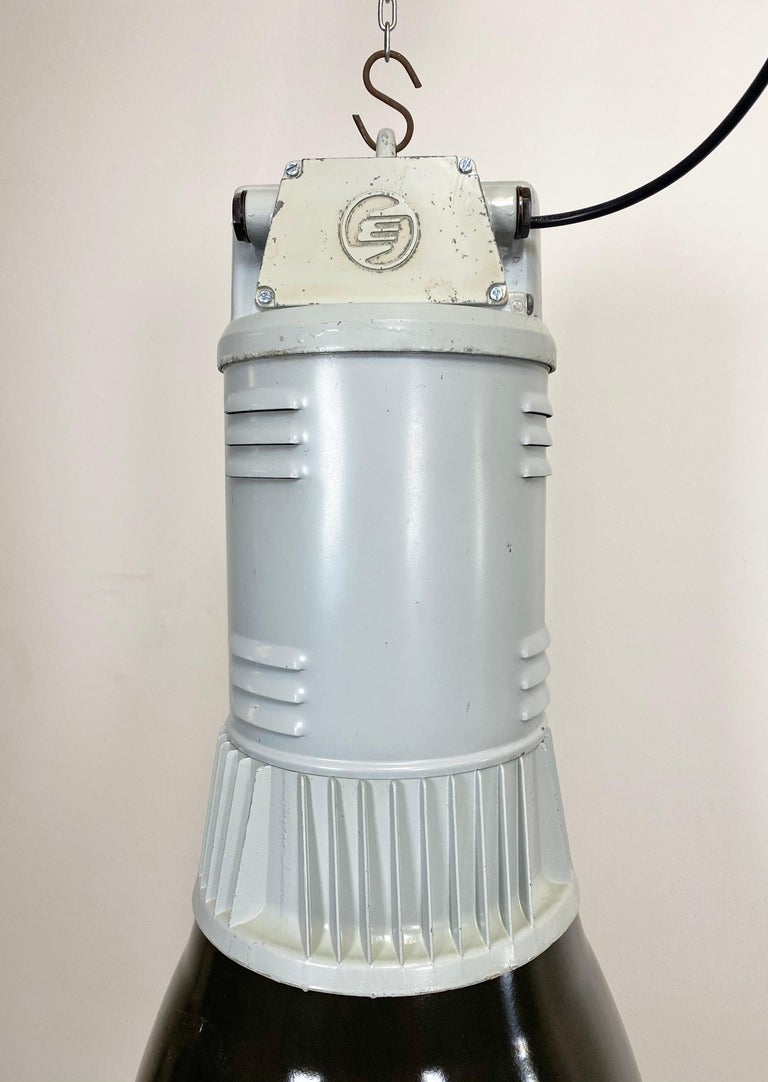 Vintage industrial hanging hall lamp made by Elektrosvit in former Czechoslovakia during the 1960s. It features black enamel shade with white interior and grey cast aluminium top. New porcelain socket requires E 27 lightbulbs. New wire. The weight