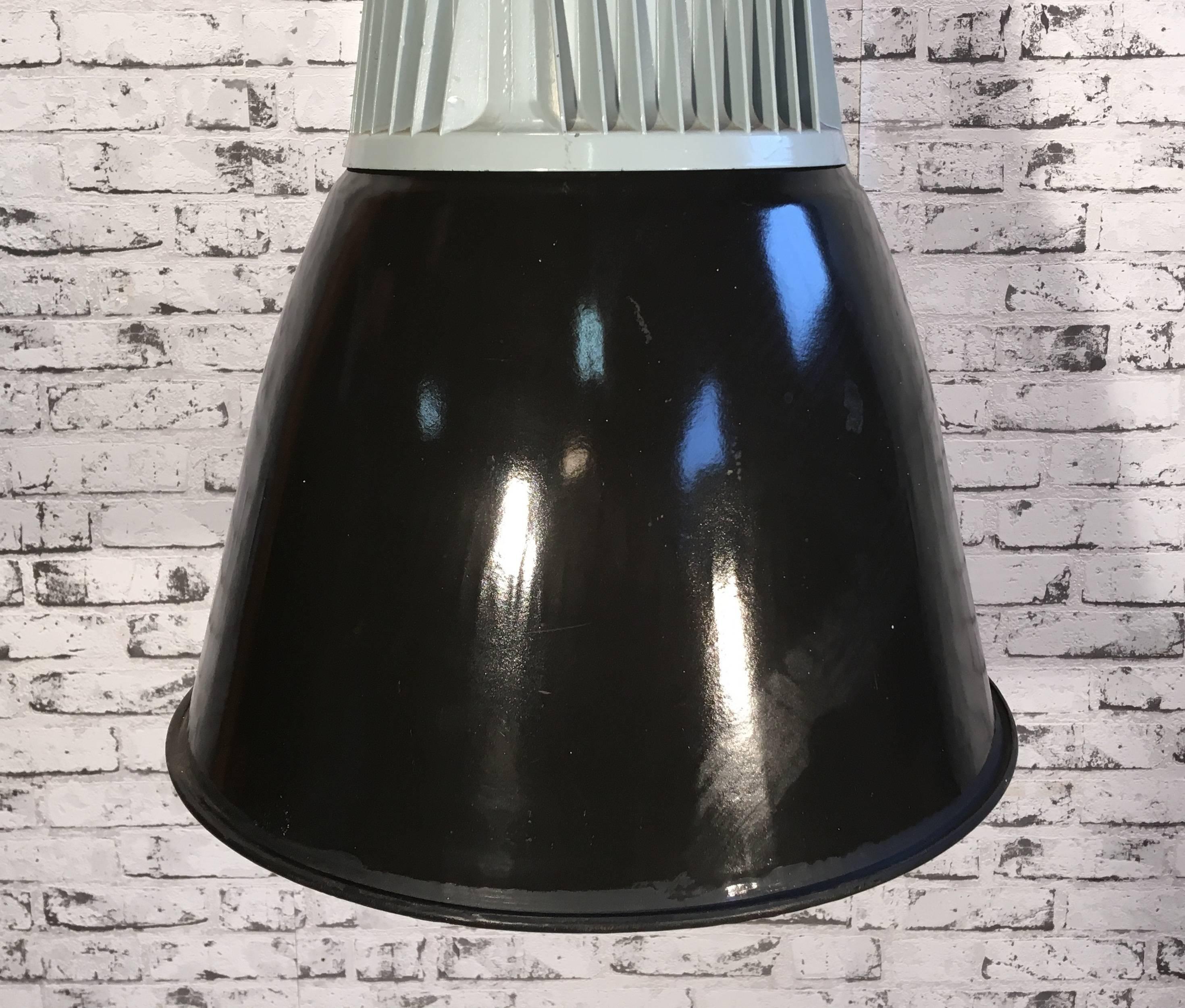 Industrial hanging lamp. Black enamel shade. White interior. Grey cast aluminium top. 
New porcelain socket for E 27 lightbulbs. New wire. Weight: 7.0 kg.