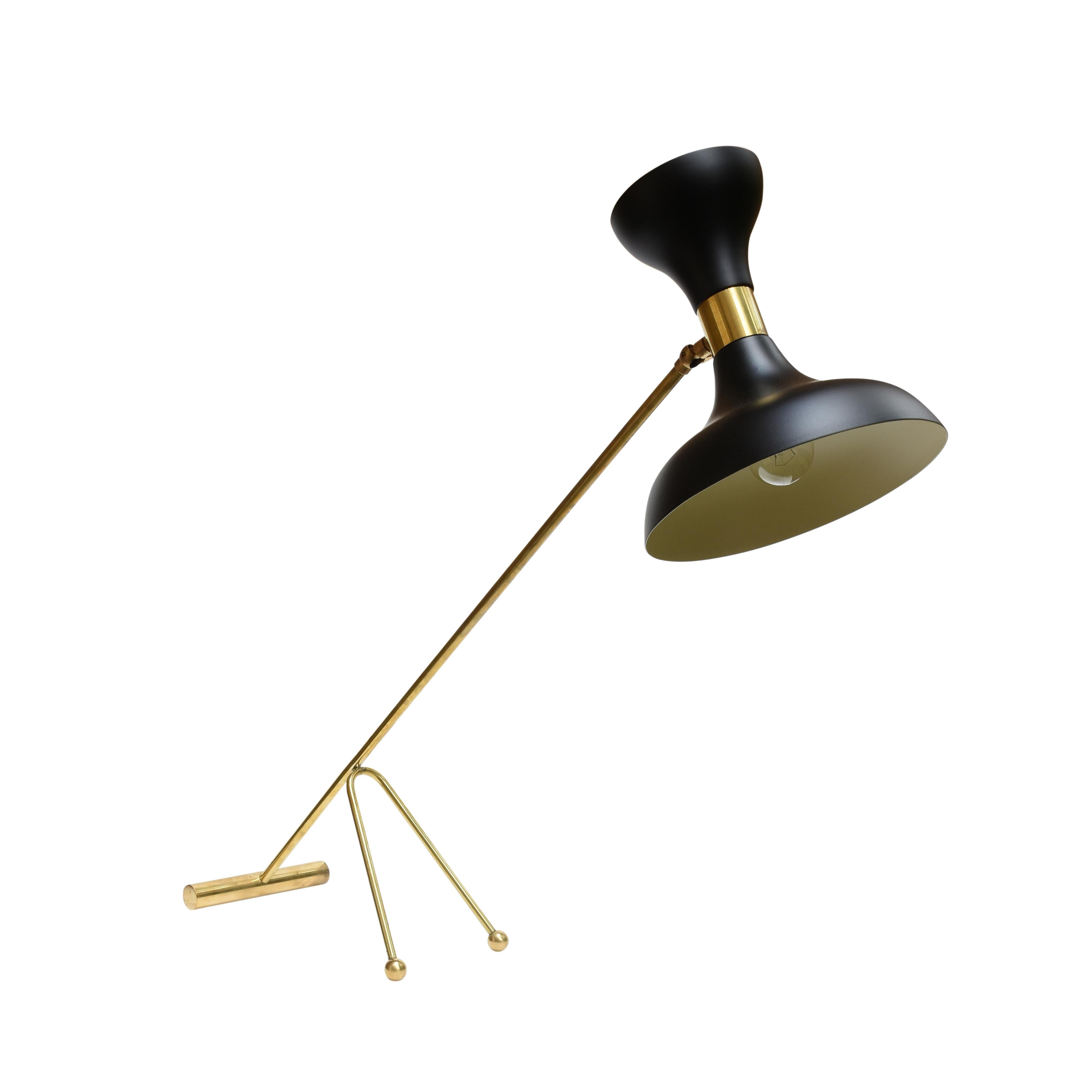 A very catching midcentury original lamp. Black enamel on metal articulated shade with a brass tubular structure standing on three points 