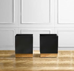 Black enamelled metal vase holder with brass details and invisible wheels