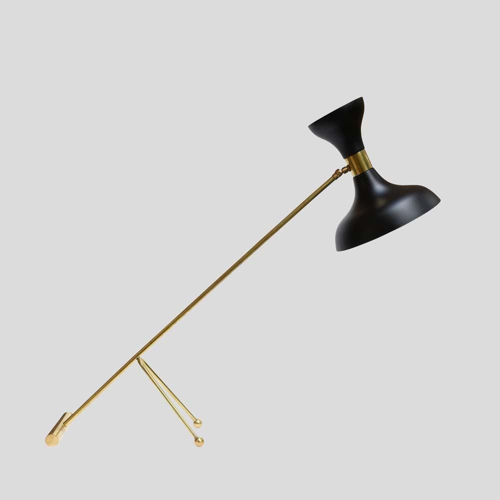 A very catching mid-century original lamp. Black enamel on metal articulated shade with a brass tubular structure standing on three points 