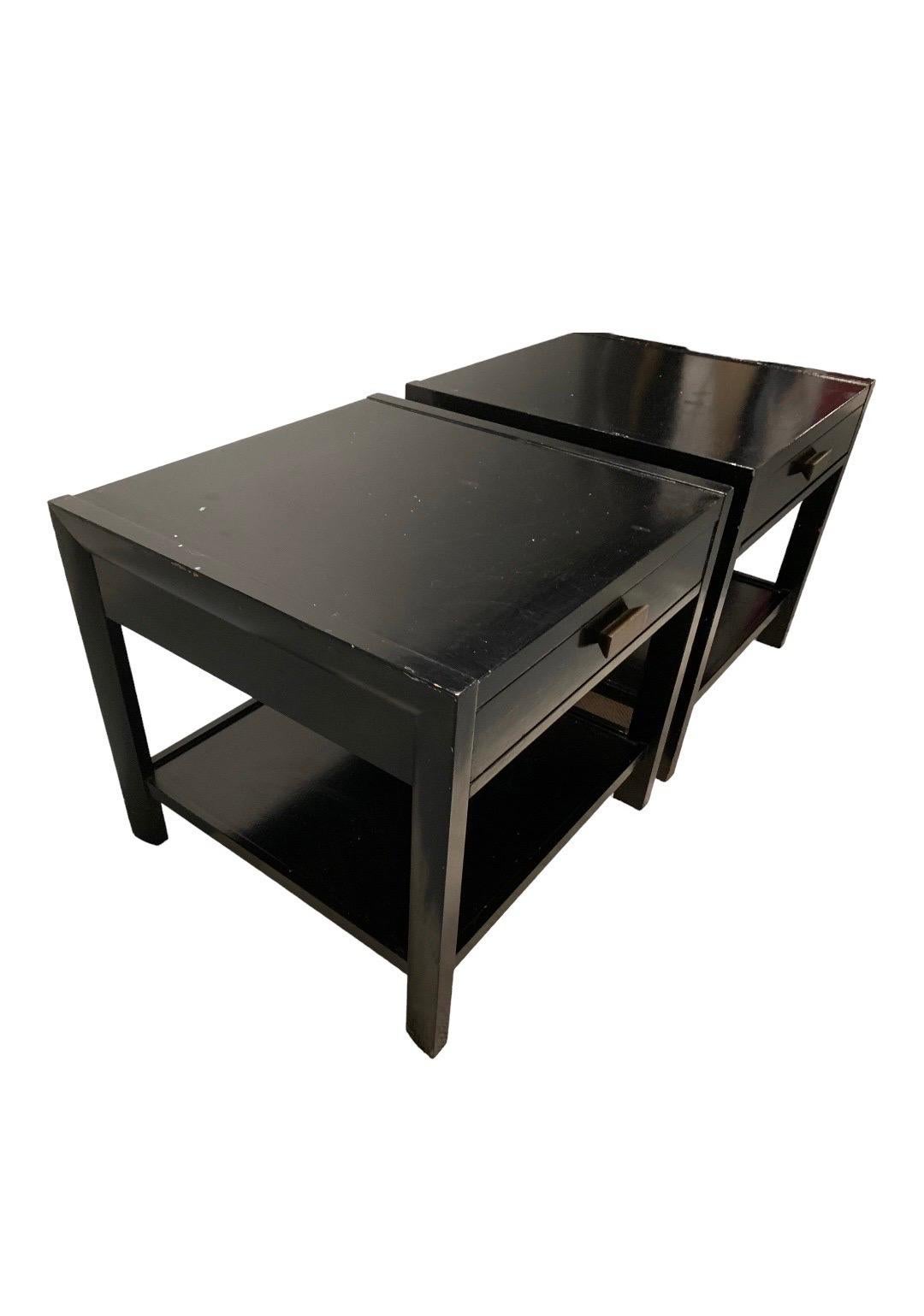 This is a pair of Occasional Tables dating to the 1950s. They are constructed of mahogany and are painted black. They closely resemble pieces that were designed by Edward Wormley, but no tags remain. 

Drawer and lower shelf utilize dovetail