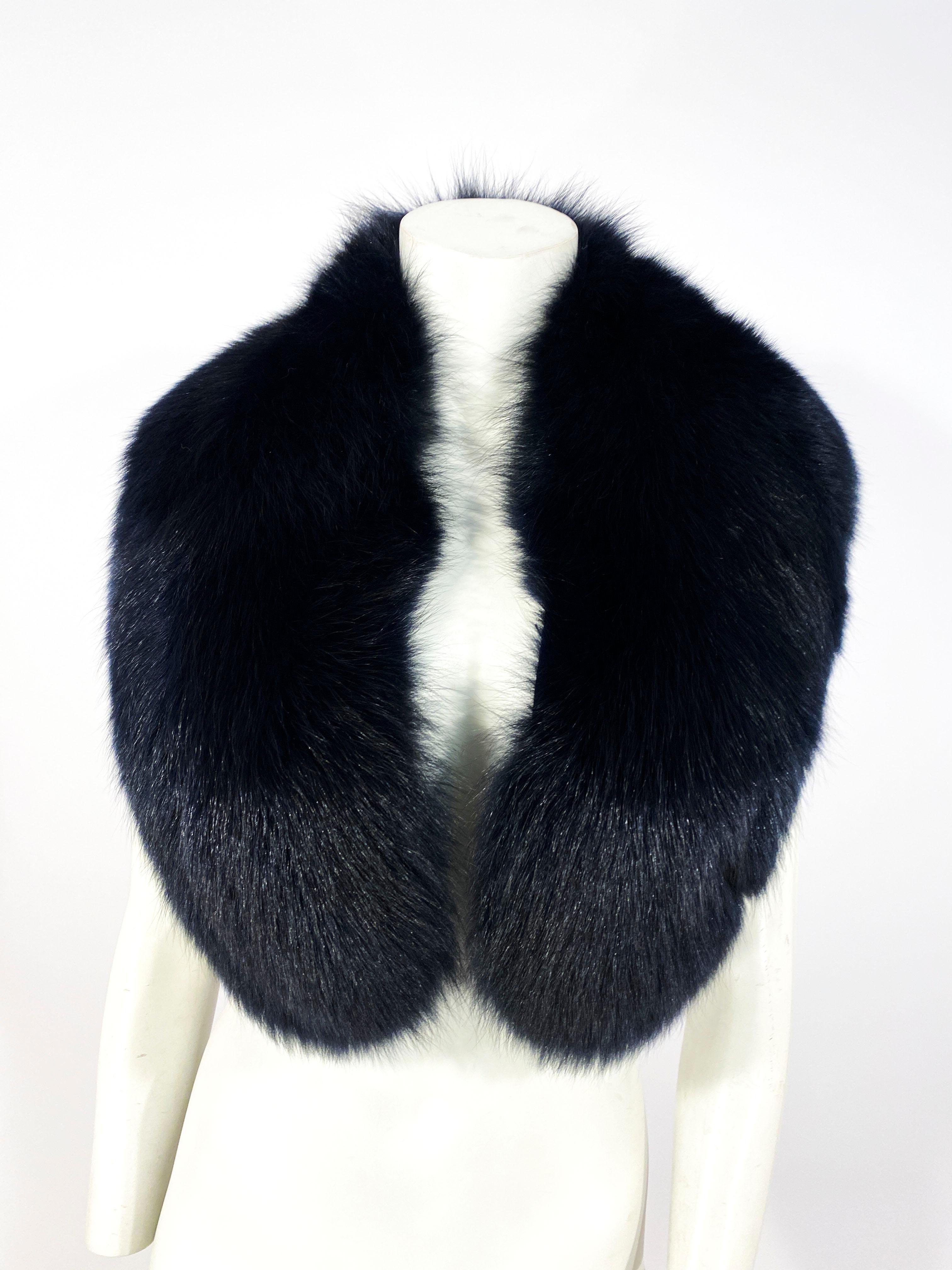 A dense black fox collar/stole that is enlarged for fullness, has a traditional fur hook, and lined in a black satin.