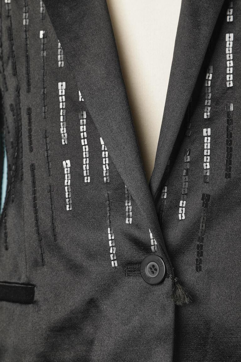 Schwarzer Abendhosen-Anzug mit Pailletten-Stickereien. Schulterpolster. Futter mit Markenzeichen. 
GRÖSSE 40(It) 36 (Fr) 6 (Us)
NEU mit Etikett