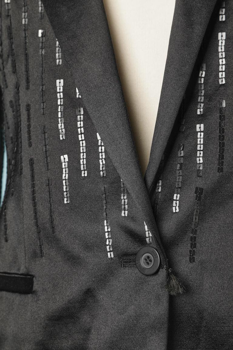 Tuta-pantalone da sera nera con ricami di paillettes. Composizione del tessuto principale: 50% cotone, 50% seta. Composizione della fodera: 60% acetato, 40% rayon. 
Spallaccio. Fodera con marchio. 
TAGLIA 40(It) 36 (Fr) 6 (Us)
NUOVO con etichetta