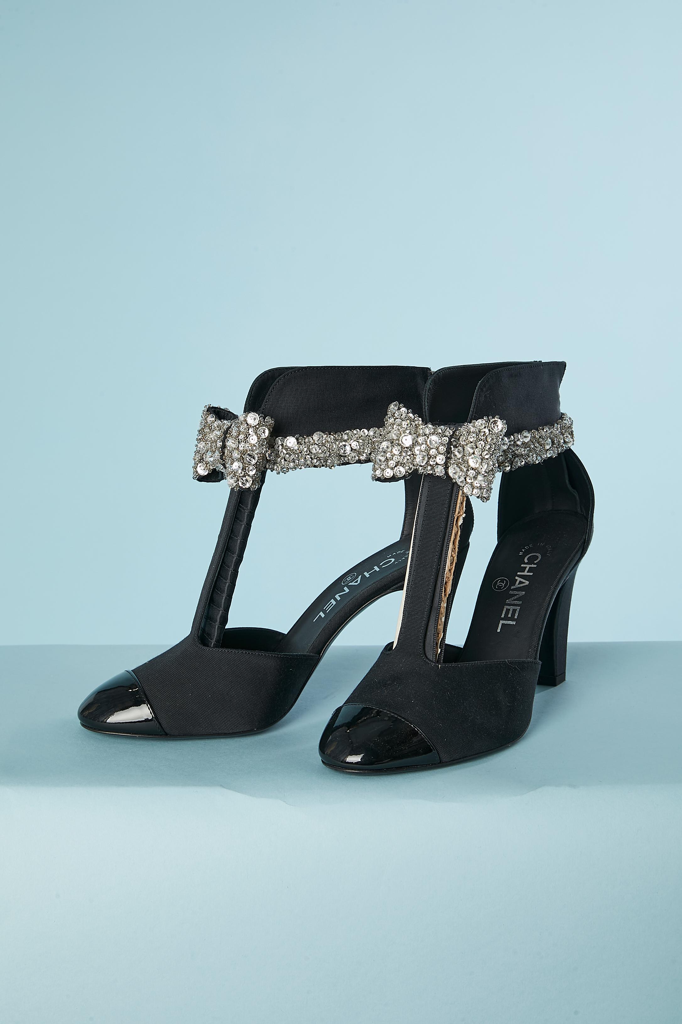 Black fabric and patent leather pump with rhinestone  and pearls bow. Zip on the middle back with black patent leather zip-puller. 