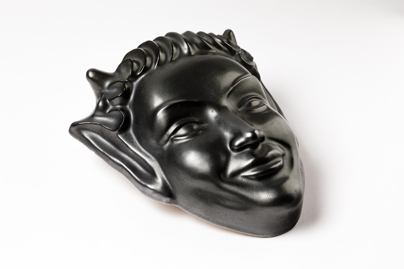 Wall ceramic mask, circa 1950

French midcentury ceramic mask with elegant black ceramic glaze color.

Original perfect conditions

Measures: Height 24 cm, large 22 cm, depth 7 cm.