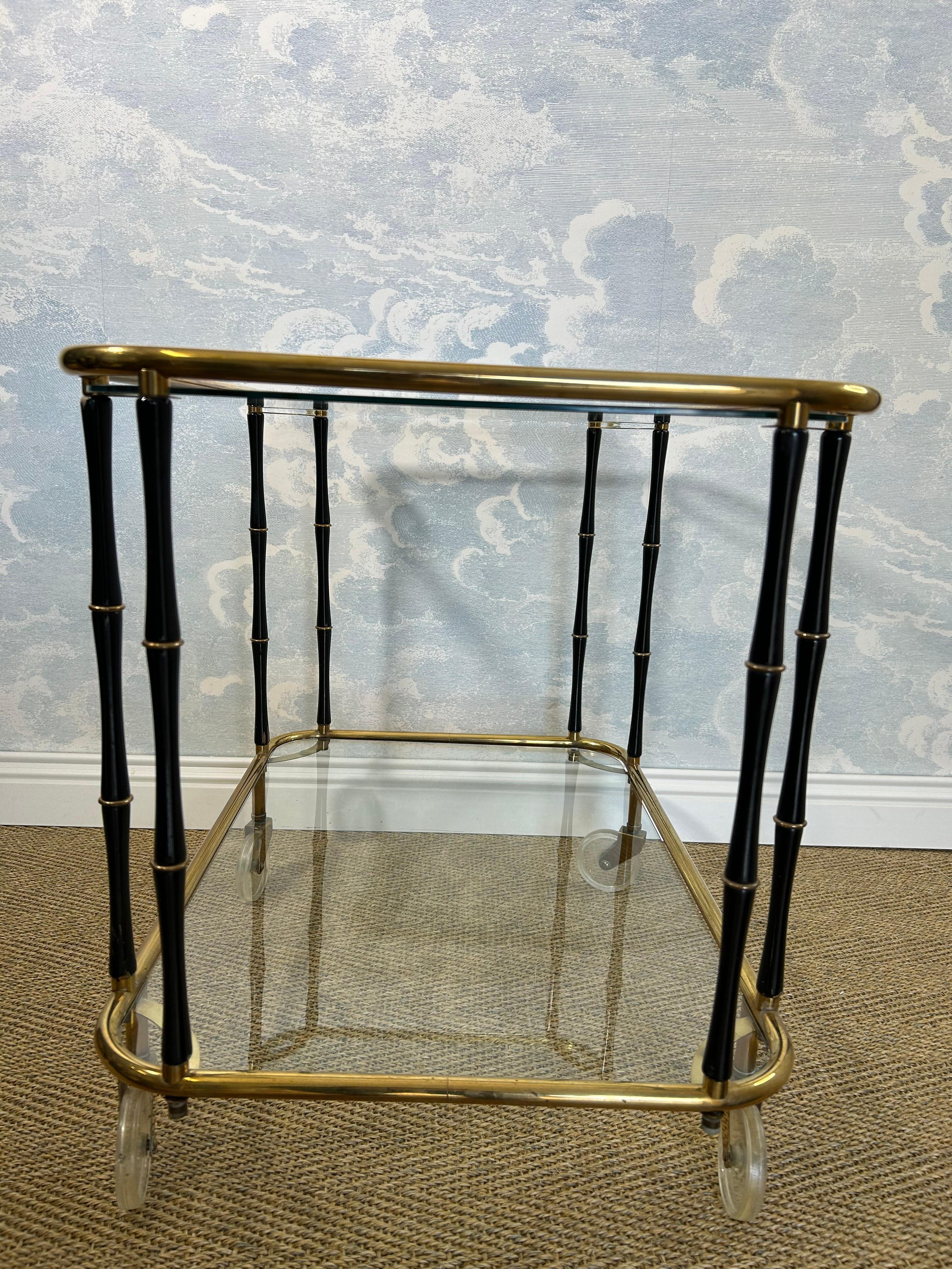 Questo superbo carrello da portata a due livelli è stato prodotto con ogni probabilità dall'illustre Maison Jansen, in Francia, negli anni '60.

Quattro piccole ruote piroettanti sostengono due telai in ottone lucido separati da otto aste in finto