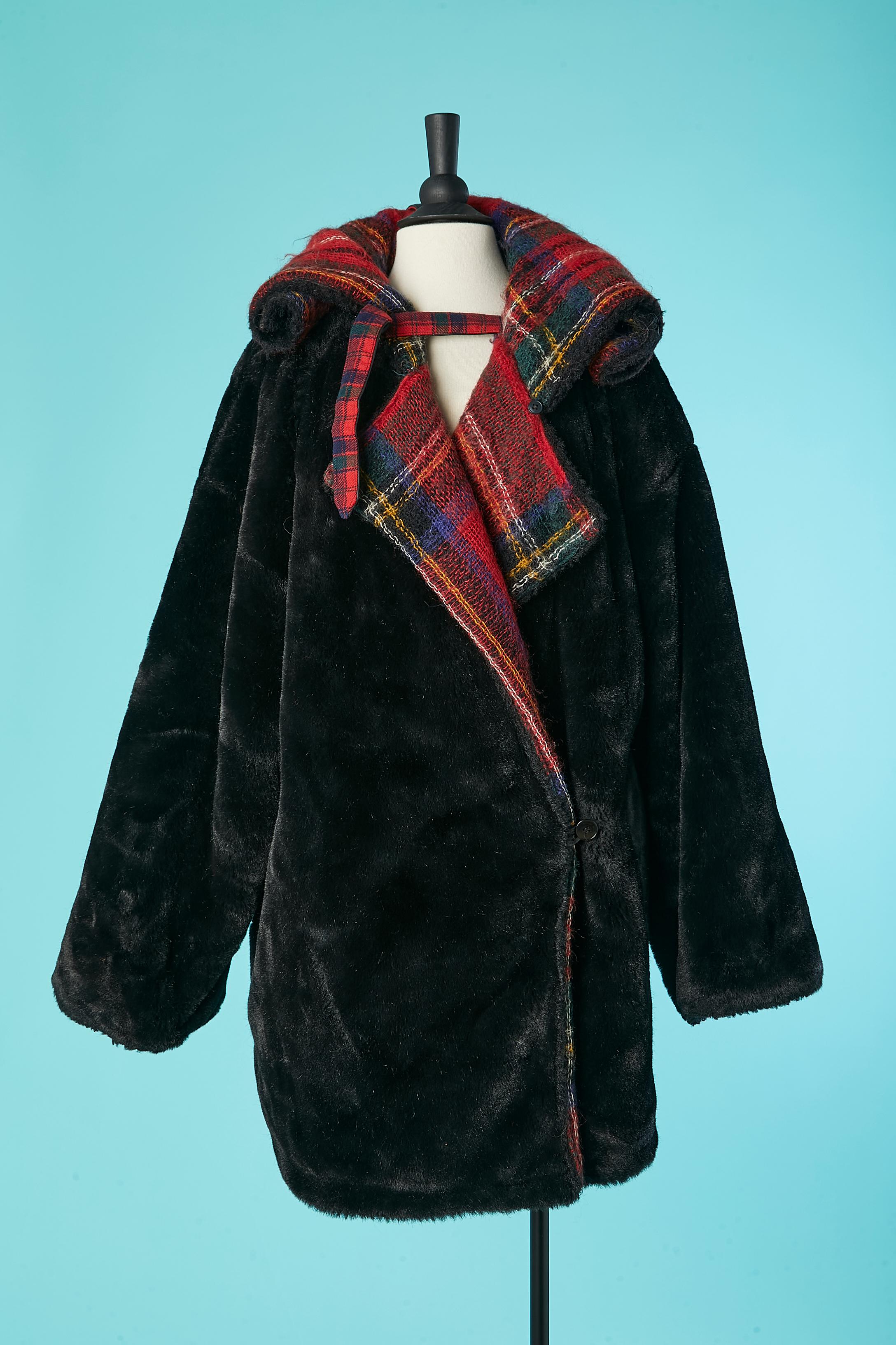 Black faux fur double-breasted coat with tartan blanket lining and hood. Leather strap and buckle closure on the top front and leather strap in the middle back to roll-up the hood. 
Fabric composition: 53% wool, 42% mohair, 5% polyamide. Faux Fur