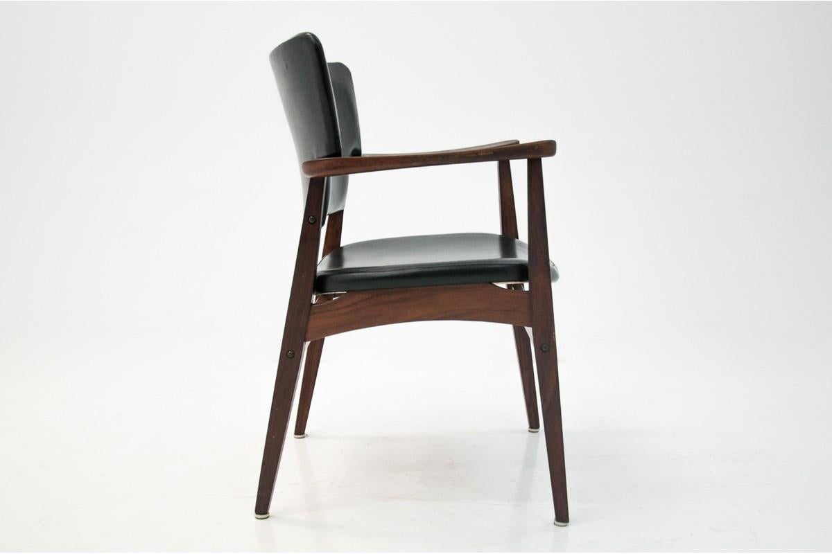 This faux leather (skai) armchair was designed by Eric Kirkegaard in the 1960s in Denmark. It is made of rosewood, it is covered with original black faux leather upholstery. It is in very good condition. The wooden elements have been renovated.